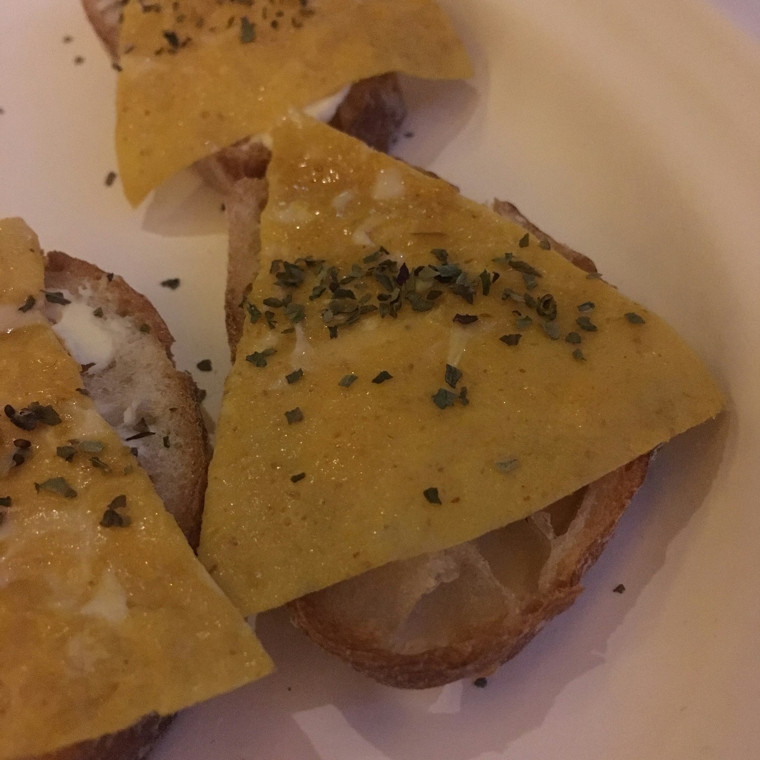 Fromage en triangle avec des herbes sur du pain grillé