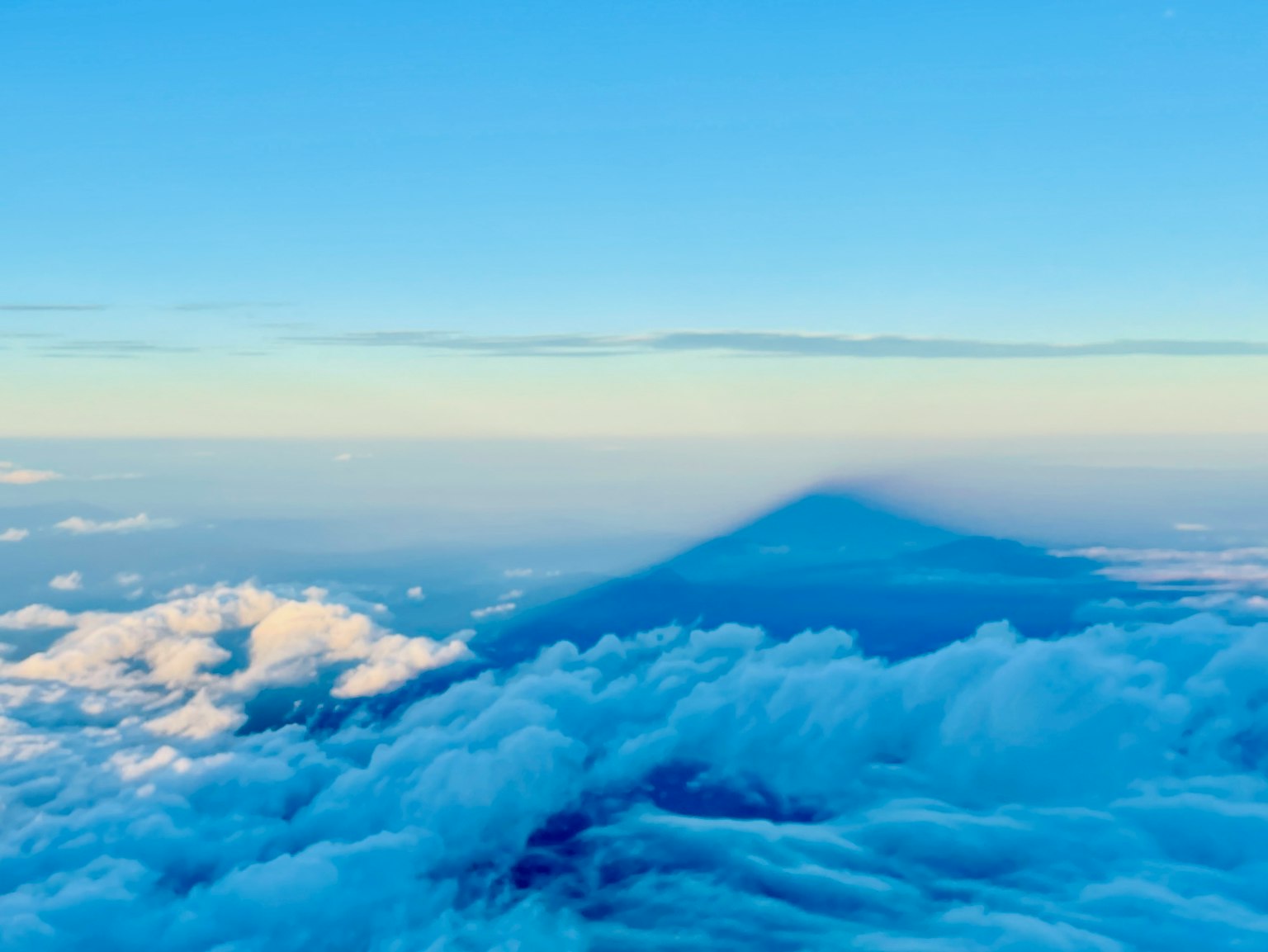 Mountain shadow over clouds with blue sky