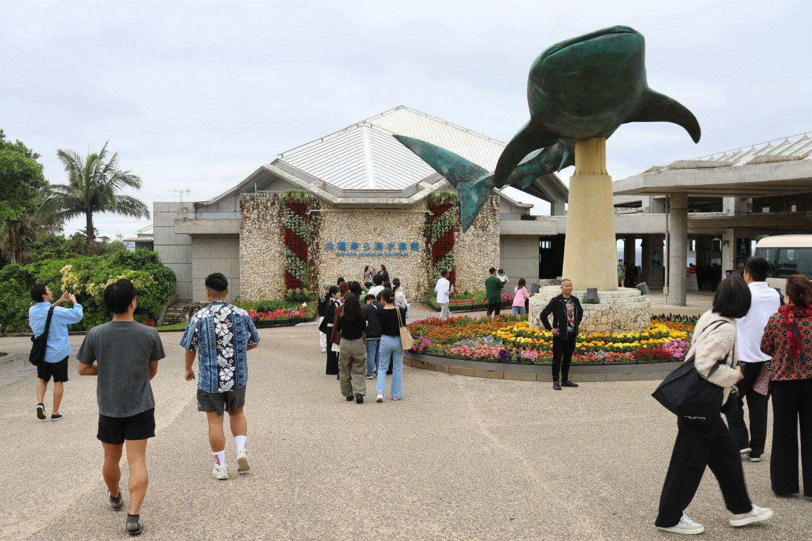 美ら海水族館の入口前でジンベエザメのモニュメントと花壇がある観光エリア