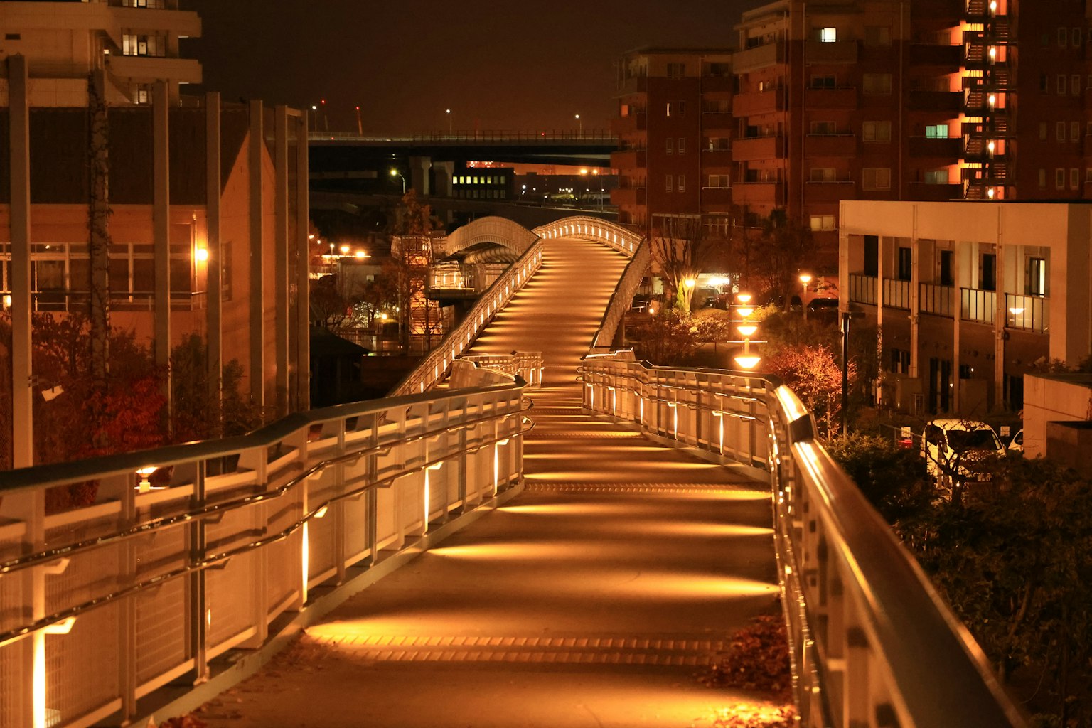 夜间城市灯光照亮的行人桥的美丽景观