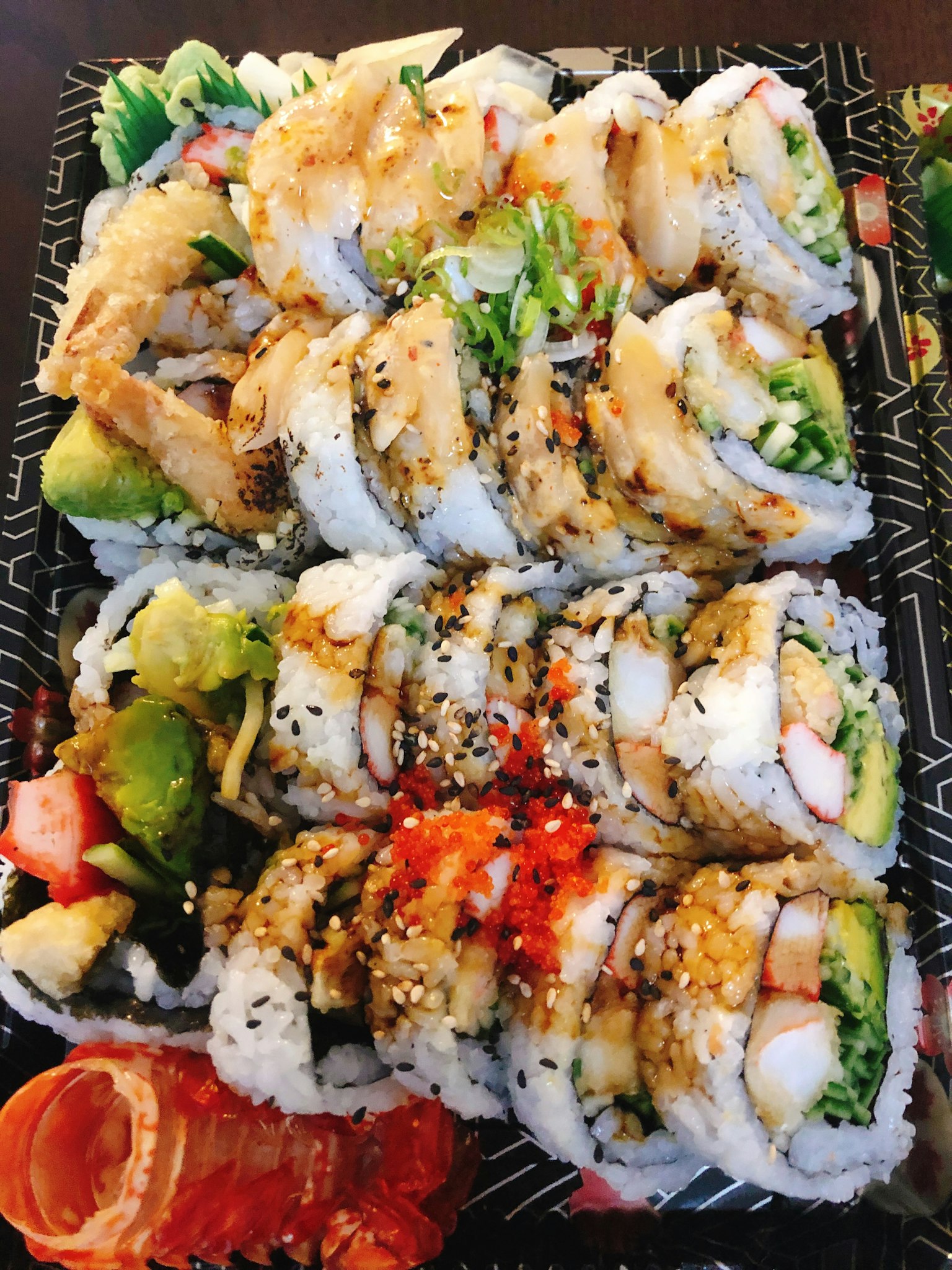 Plato de rollos de sushi frescos con ingredientes y coberturas coloridas