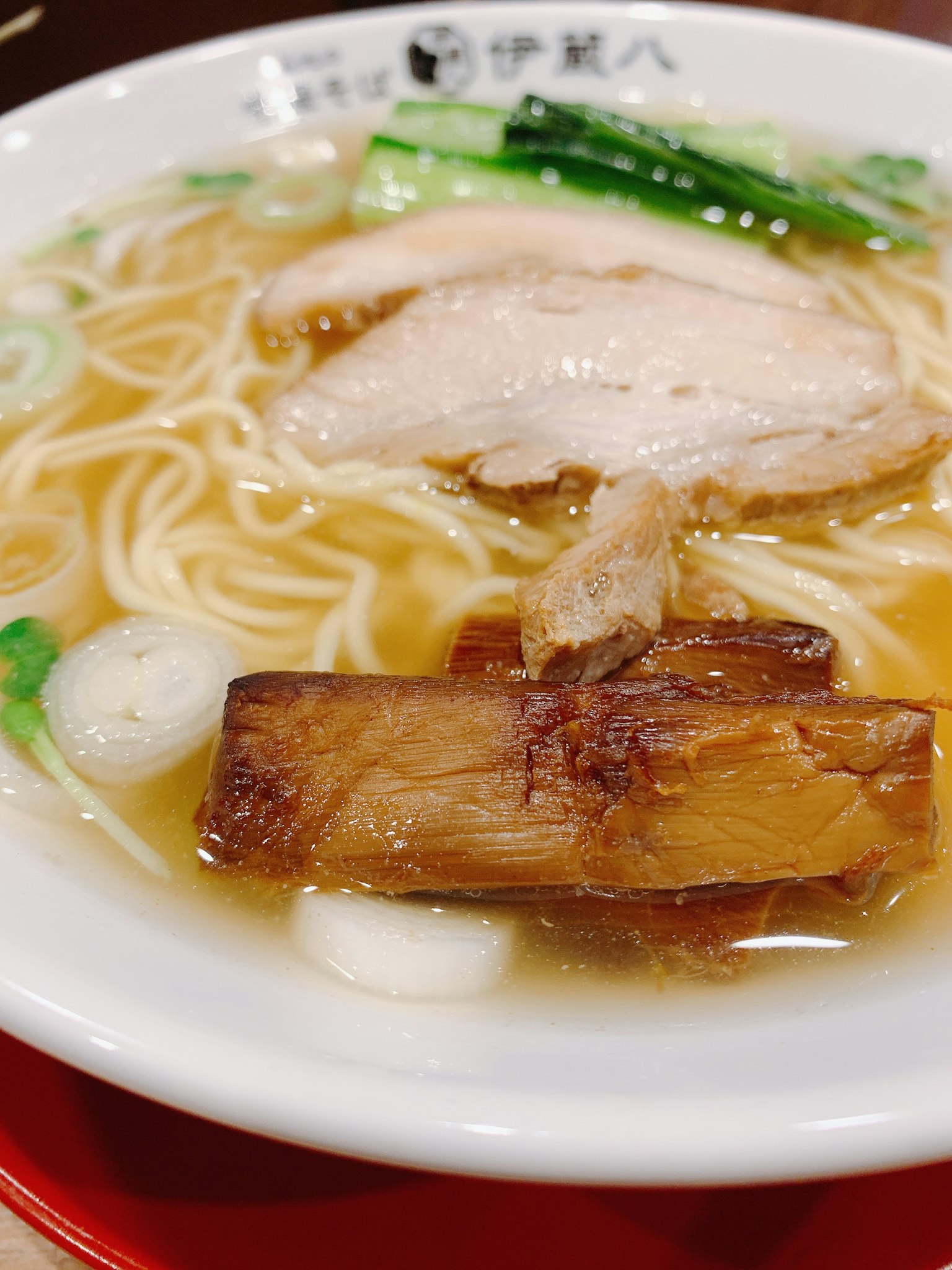 슬라이스된 닭고기와 삼겹살이 얹힌 라면 그릇