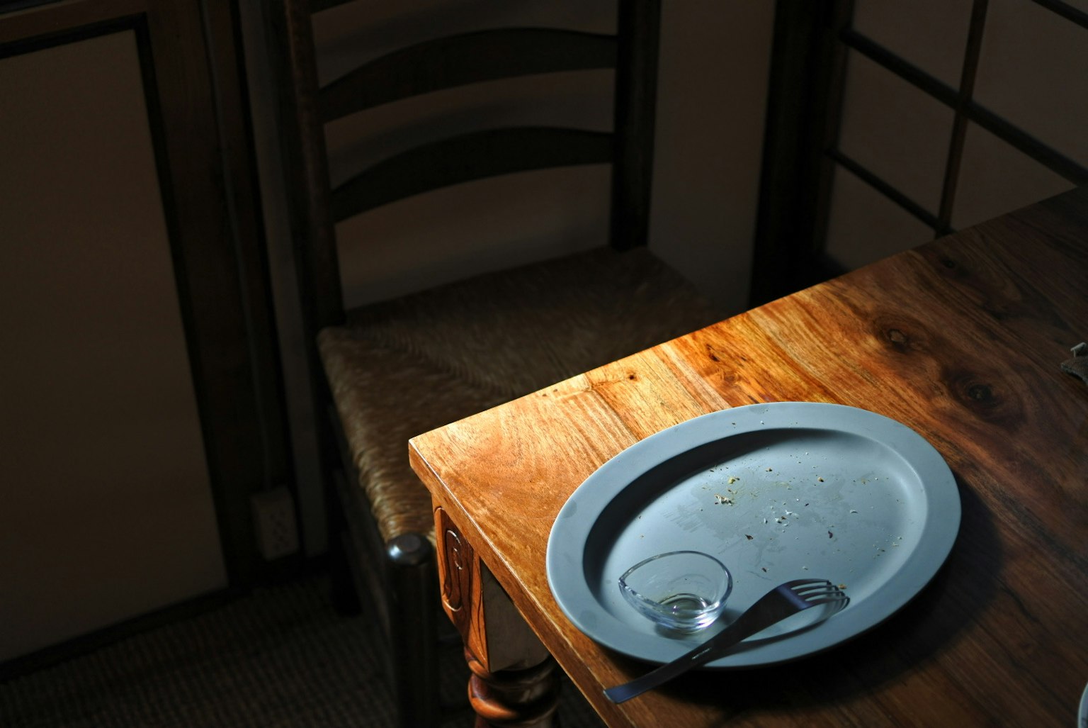 Une assiette bleue et une cuillère sur une table en bois