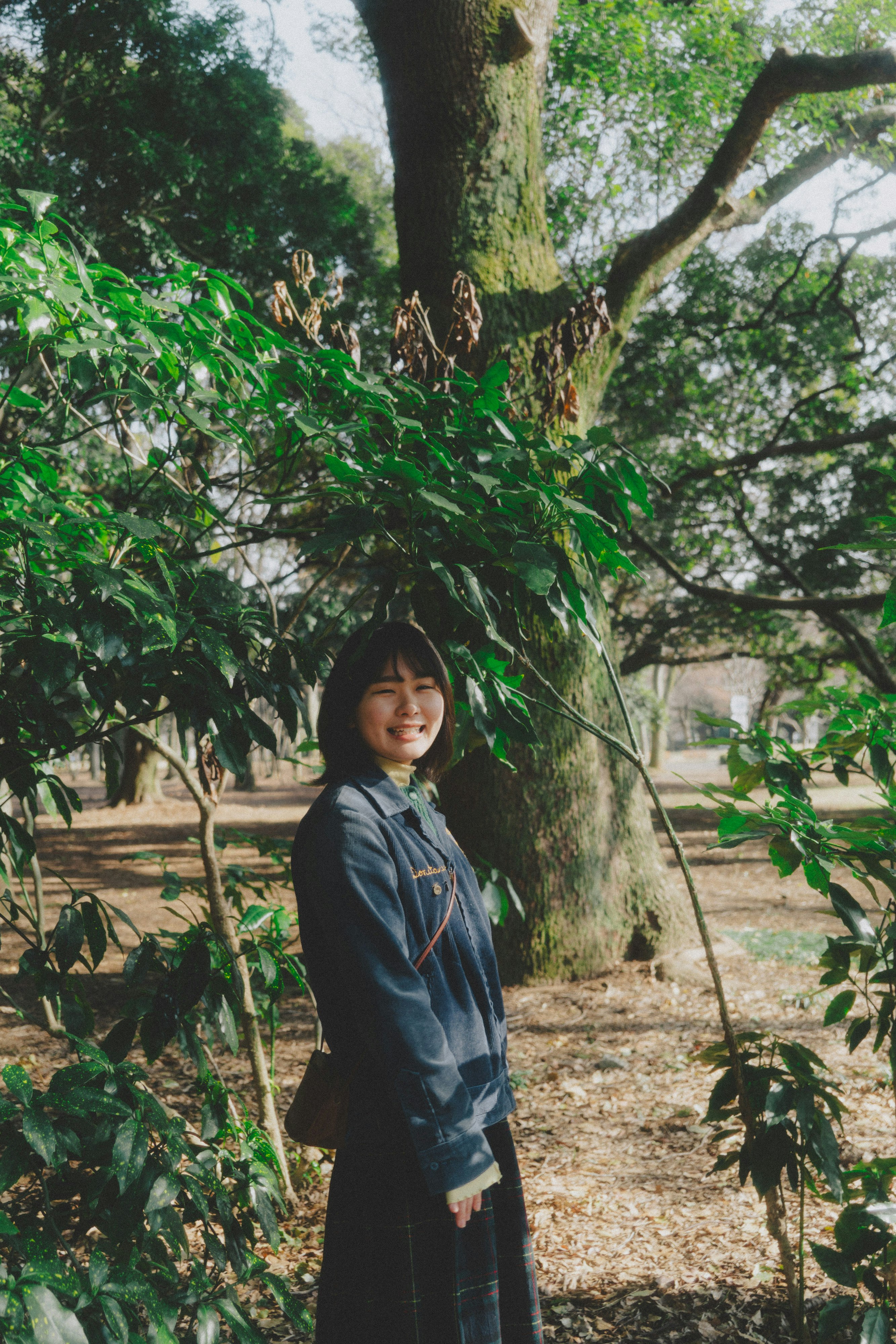 woman standing on a path surrounded by trees