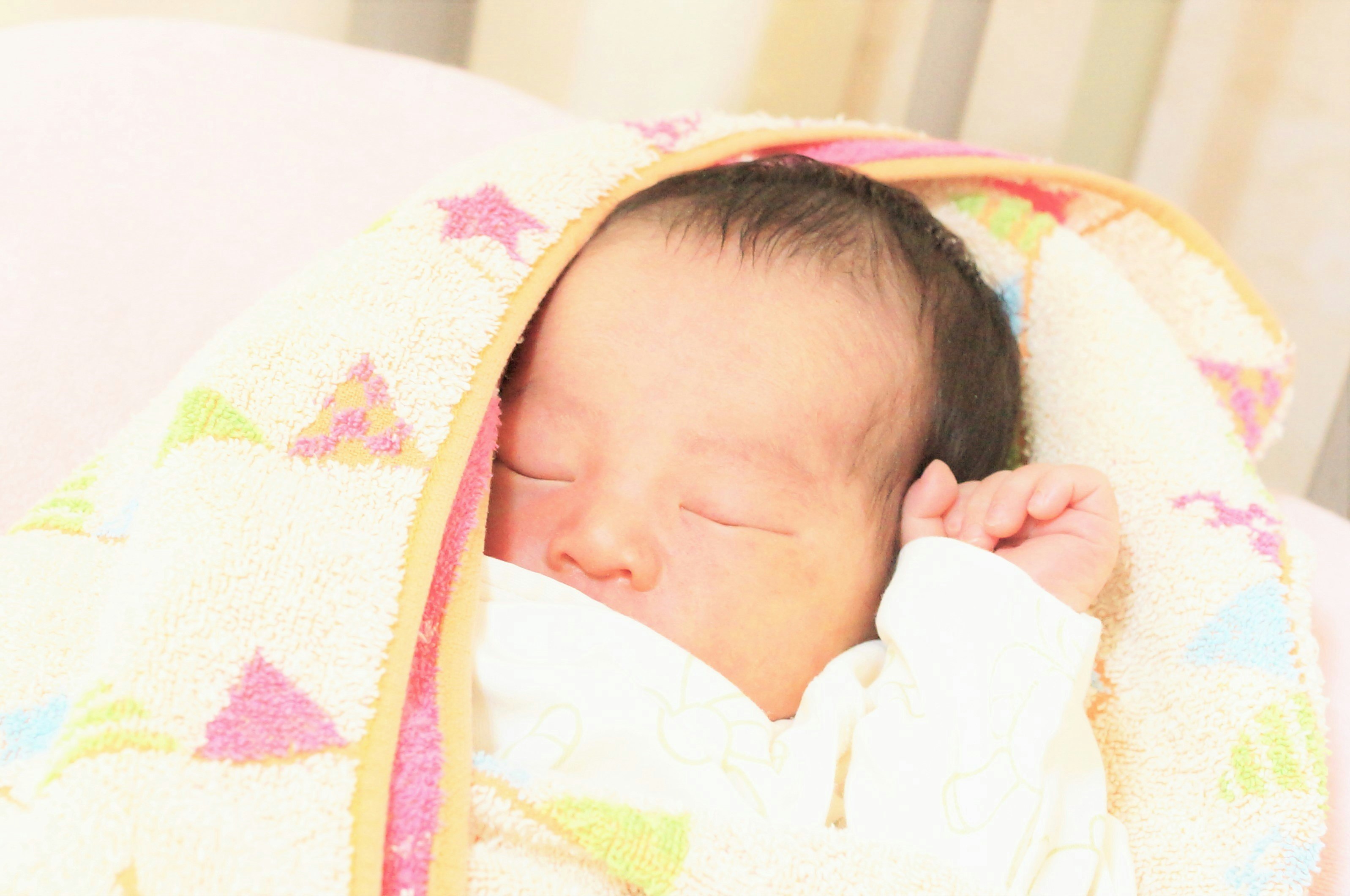 ふわふわの毛布に包まれた新生児の寝顔