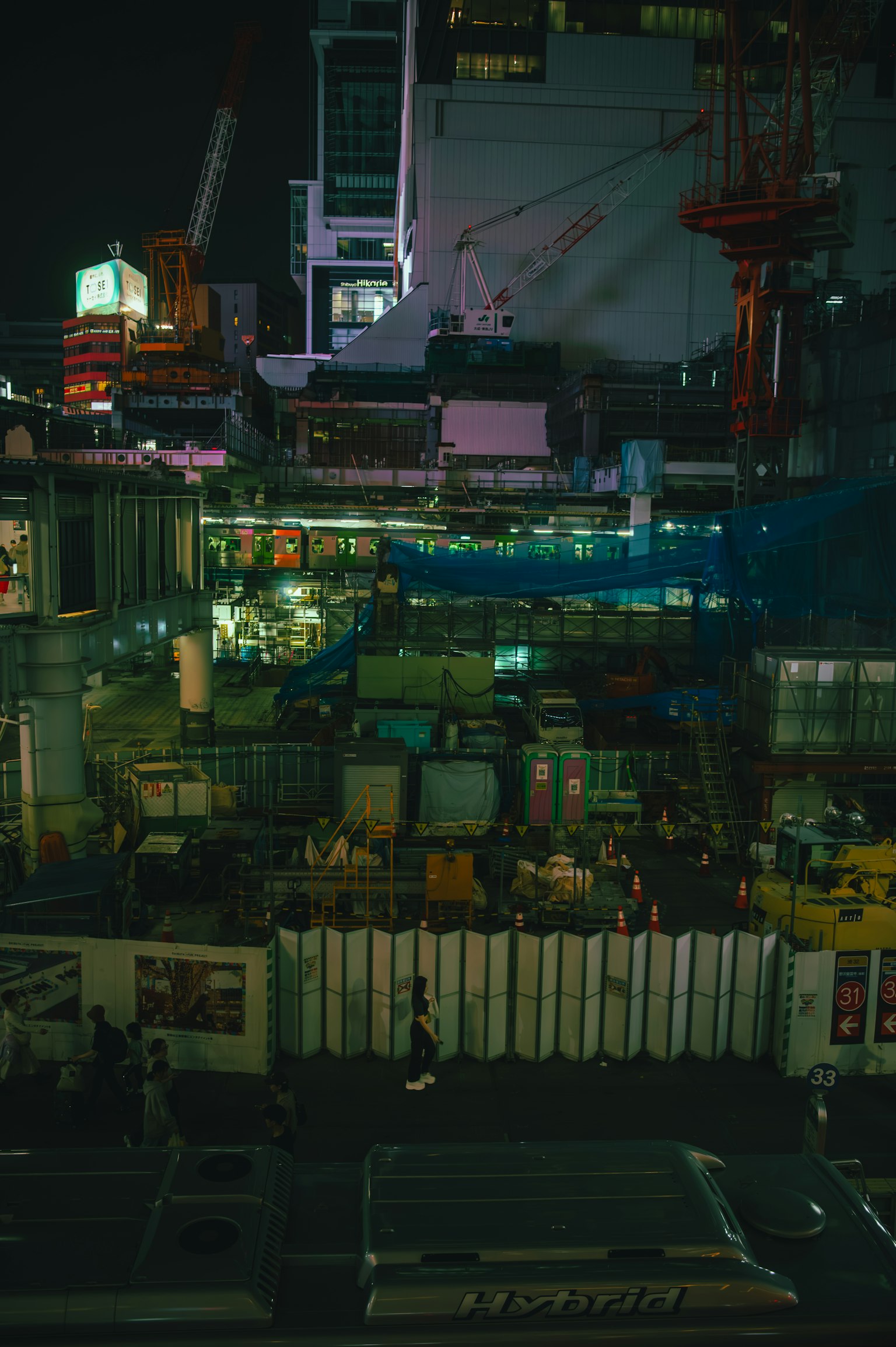 Sitio de construcción iluminado por la noche con estructuras complejas