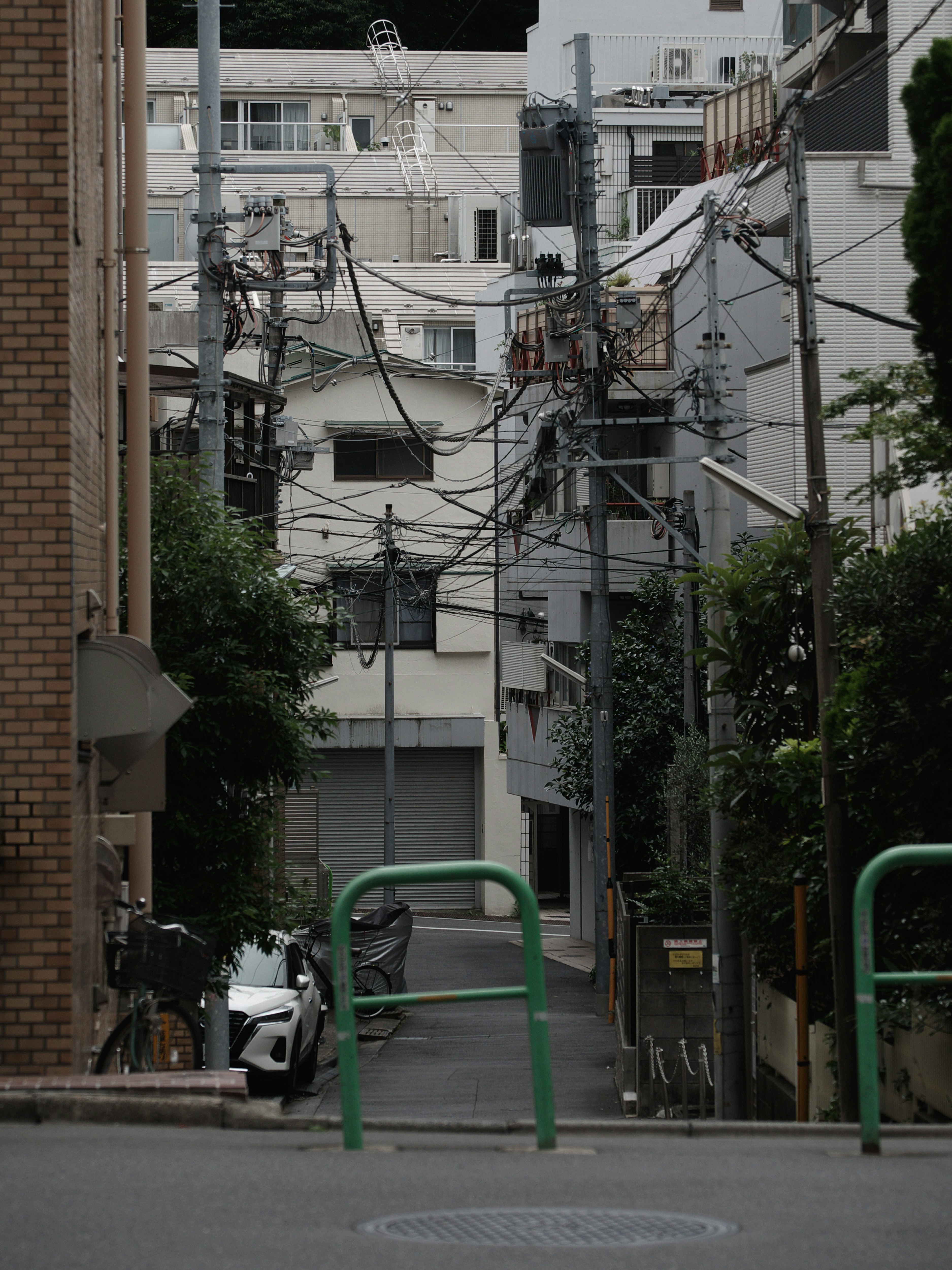 narrow alley with dense overhead power lines and tightly packed buildings