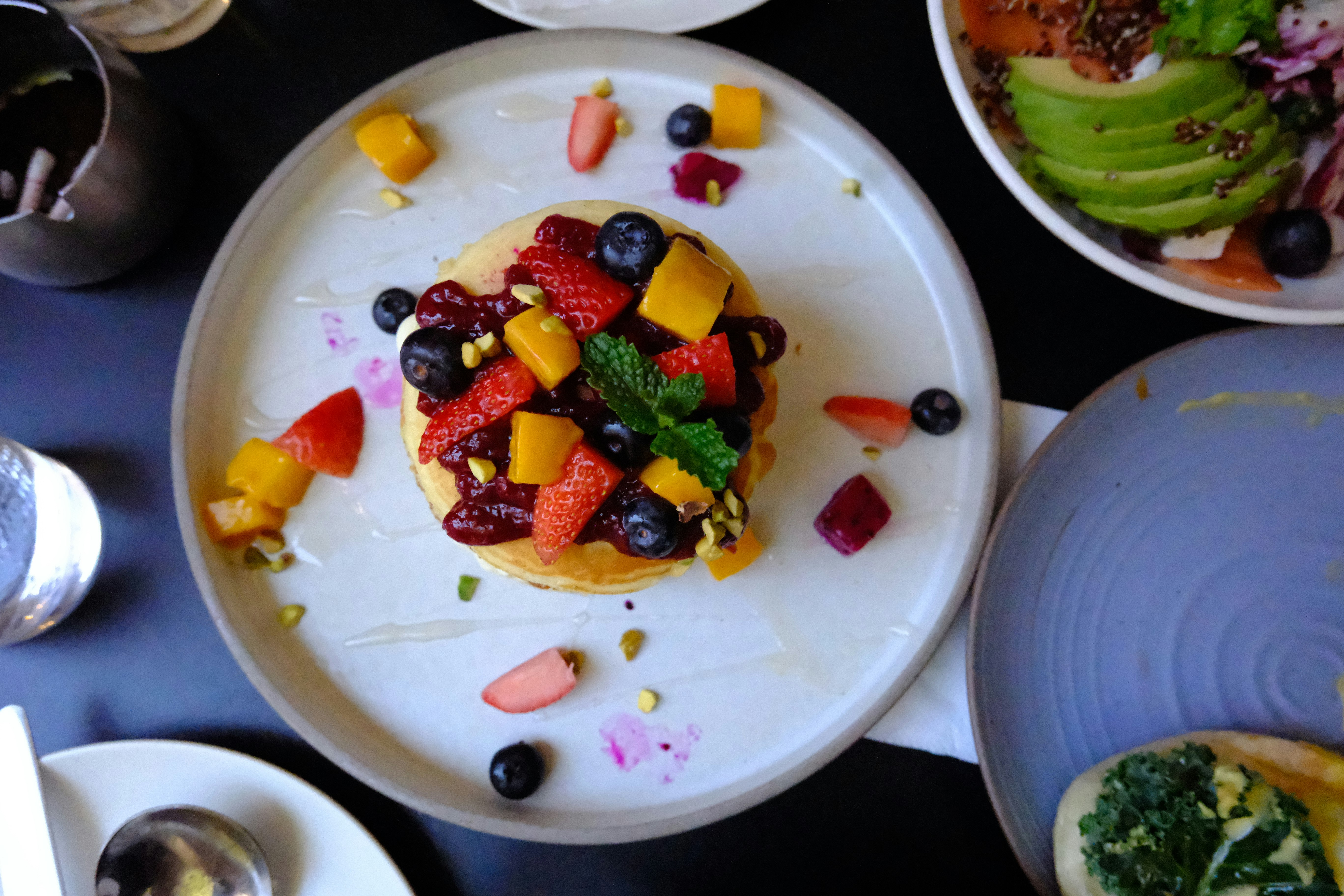 weißer Teller mit Obstmix aus Erdbeeren und Blaubeeren
