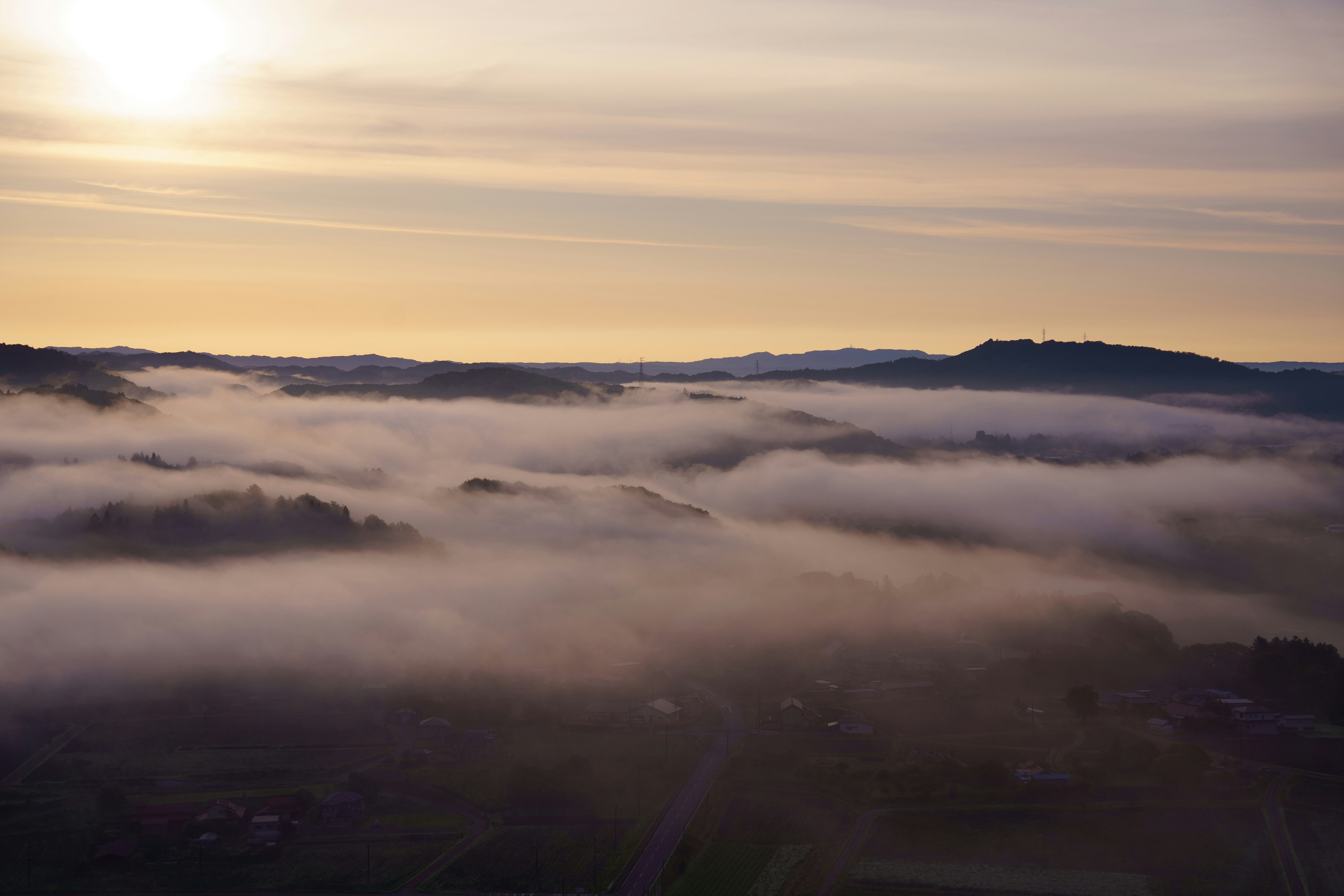 vista mattutina di una valle nella nebbia e colline lontane