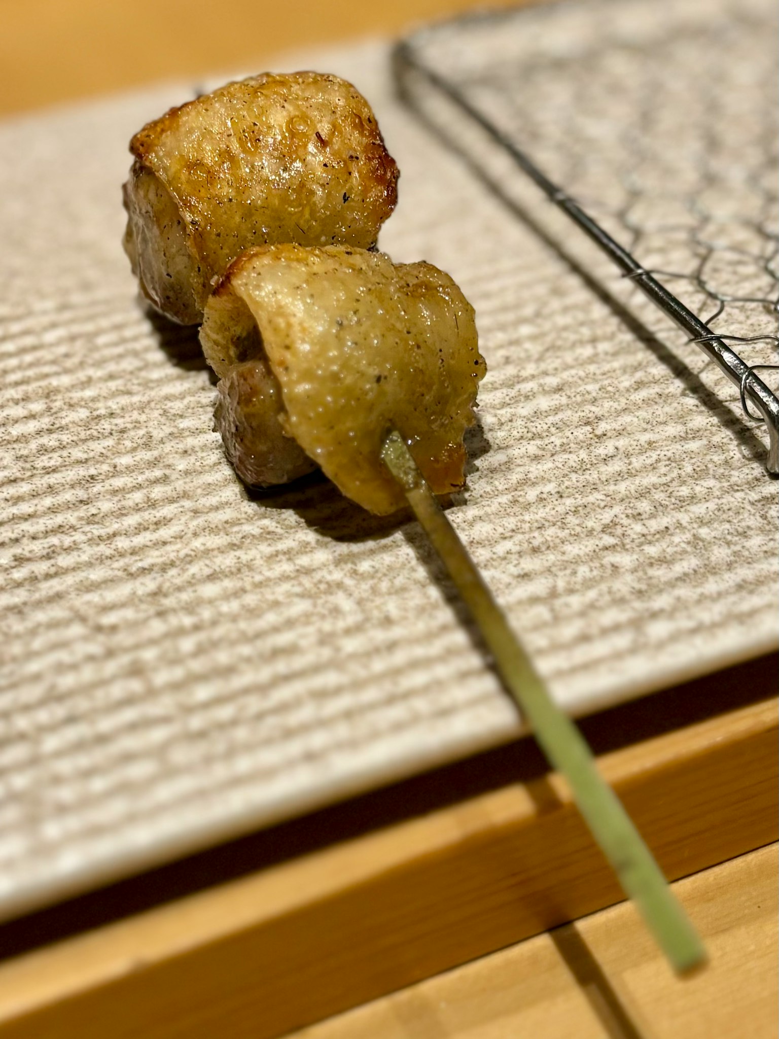 Grilled chicken skewers placed on a textured plate