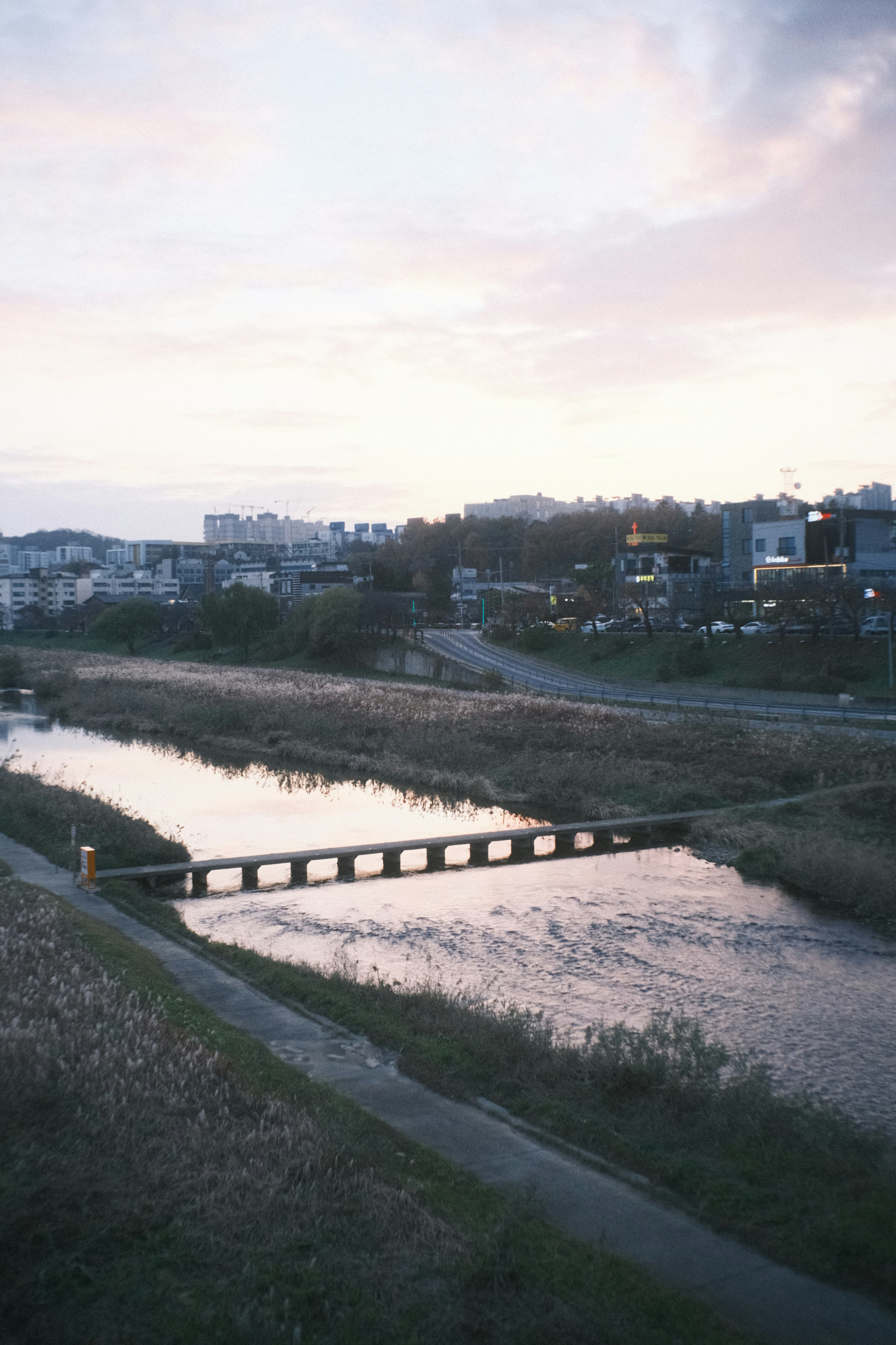 川沿いの遊歩道と夕暮れの街並み