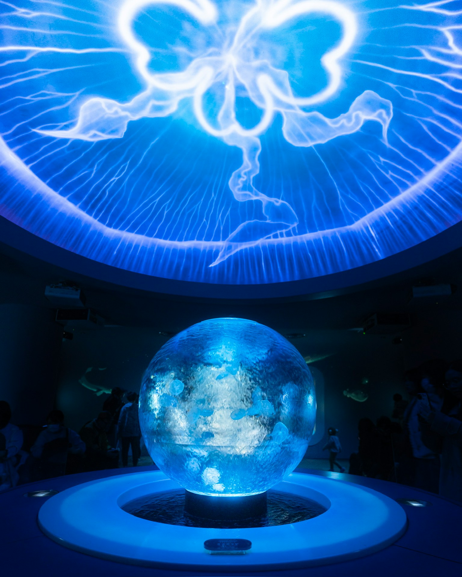 A glowing blue sphere surrounded by an ethereal ceiling design