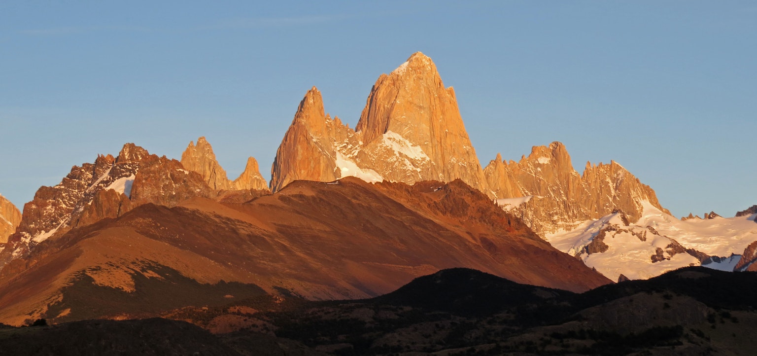 Chaîne de montagnes pittoresque avec des sommets enneigés illuminés par le coucher de soleil