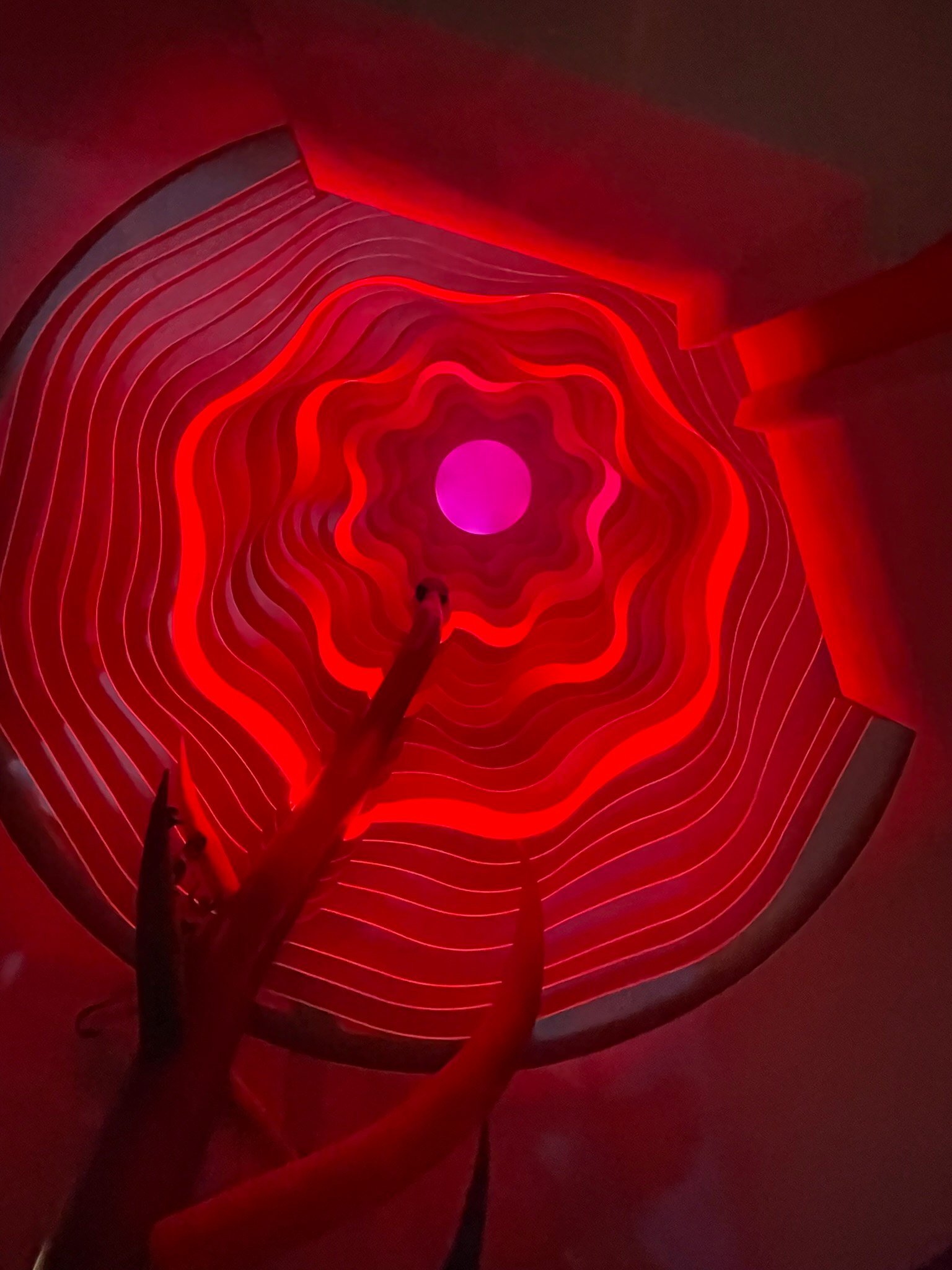 Innensicht einer Decke mit spiralförmigen roten Lichtmustern