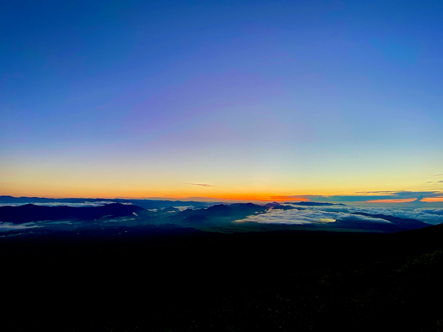 Vista panorámica de un cielo al atardecer con siluetas de montañas