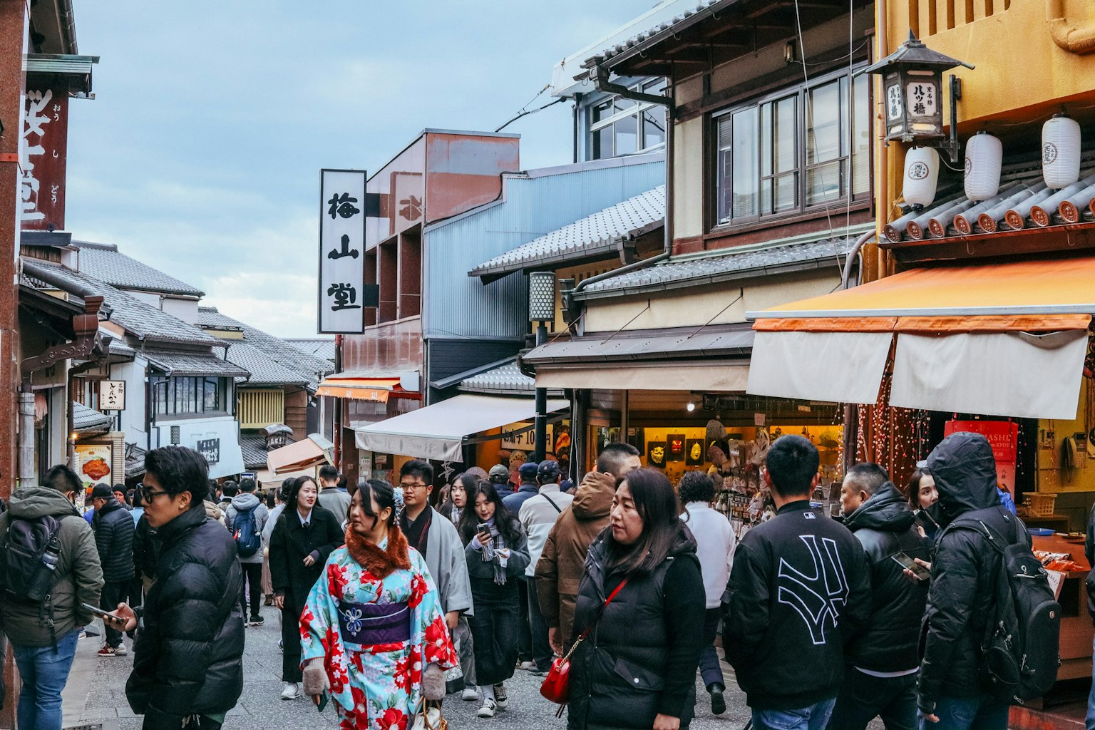 Calle comercial bulliciosa con una mujer en kimono caminando