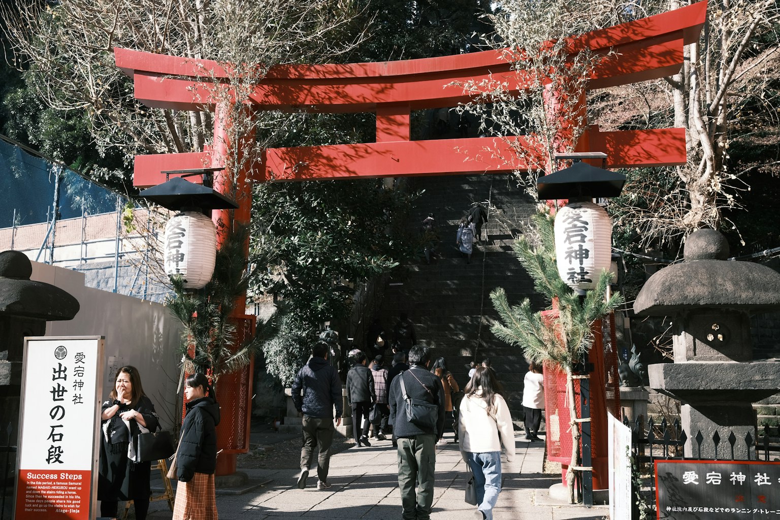 Ingresso di un santuario con un torii rosso e visitatori