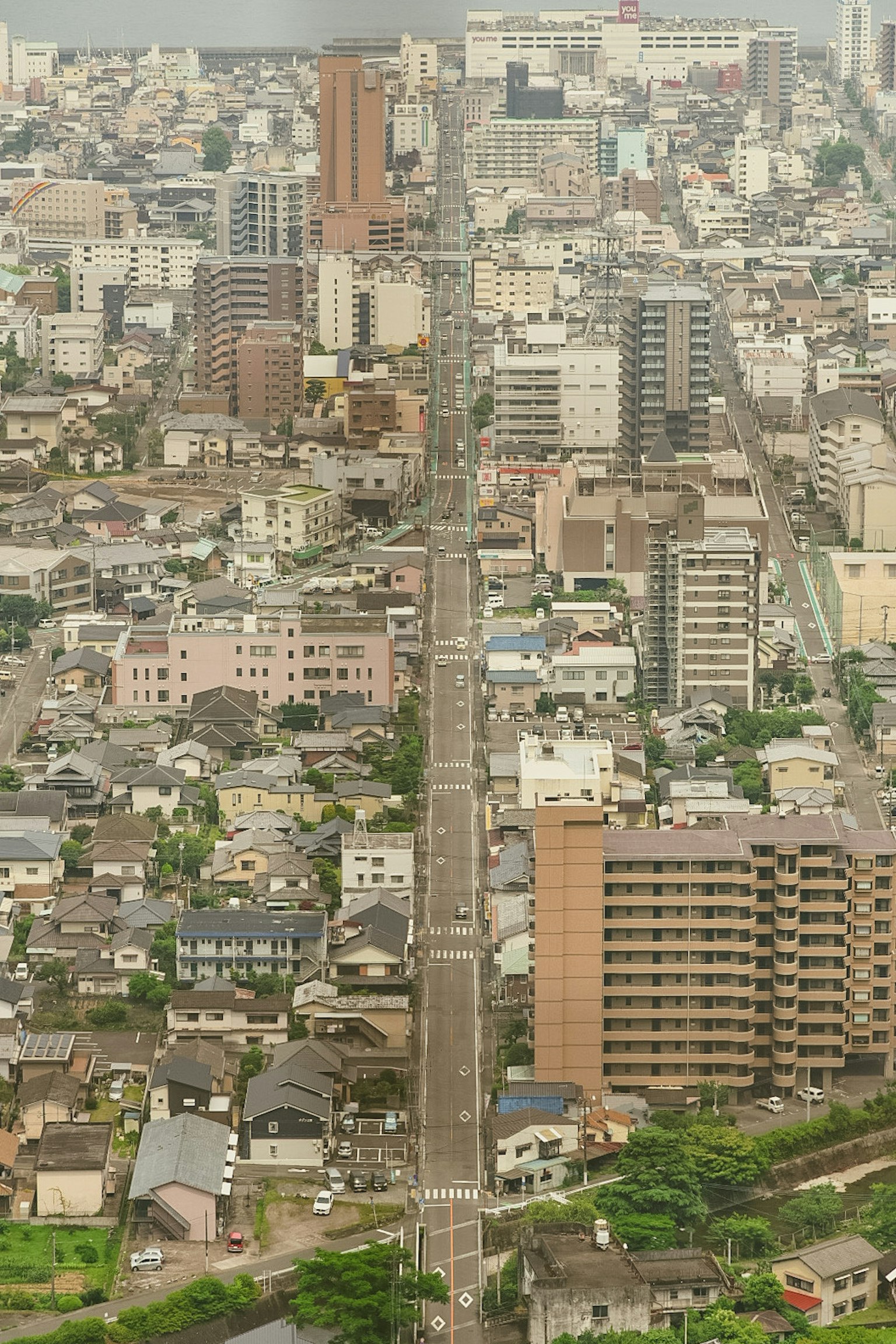 都市の高層ビルと住宅が並ぶ風景 道路が中央に走る