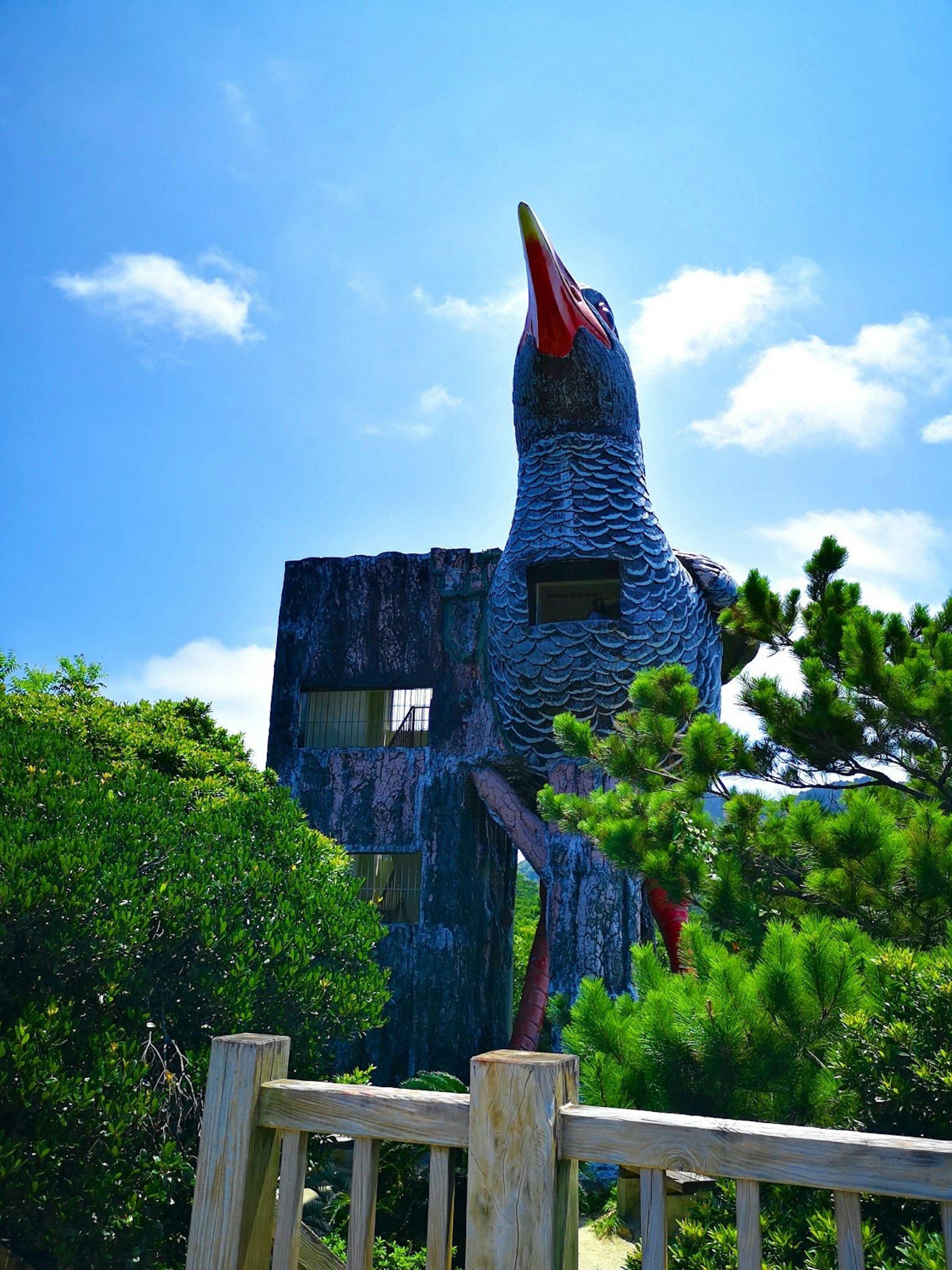 Grande sculpture d'oiseau s'élevant sous le ciel bleu
