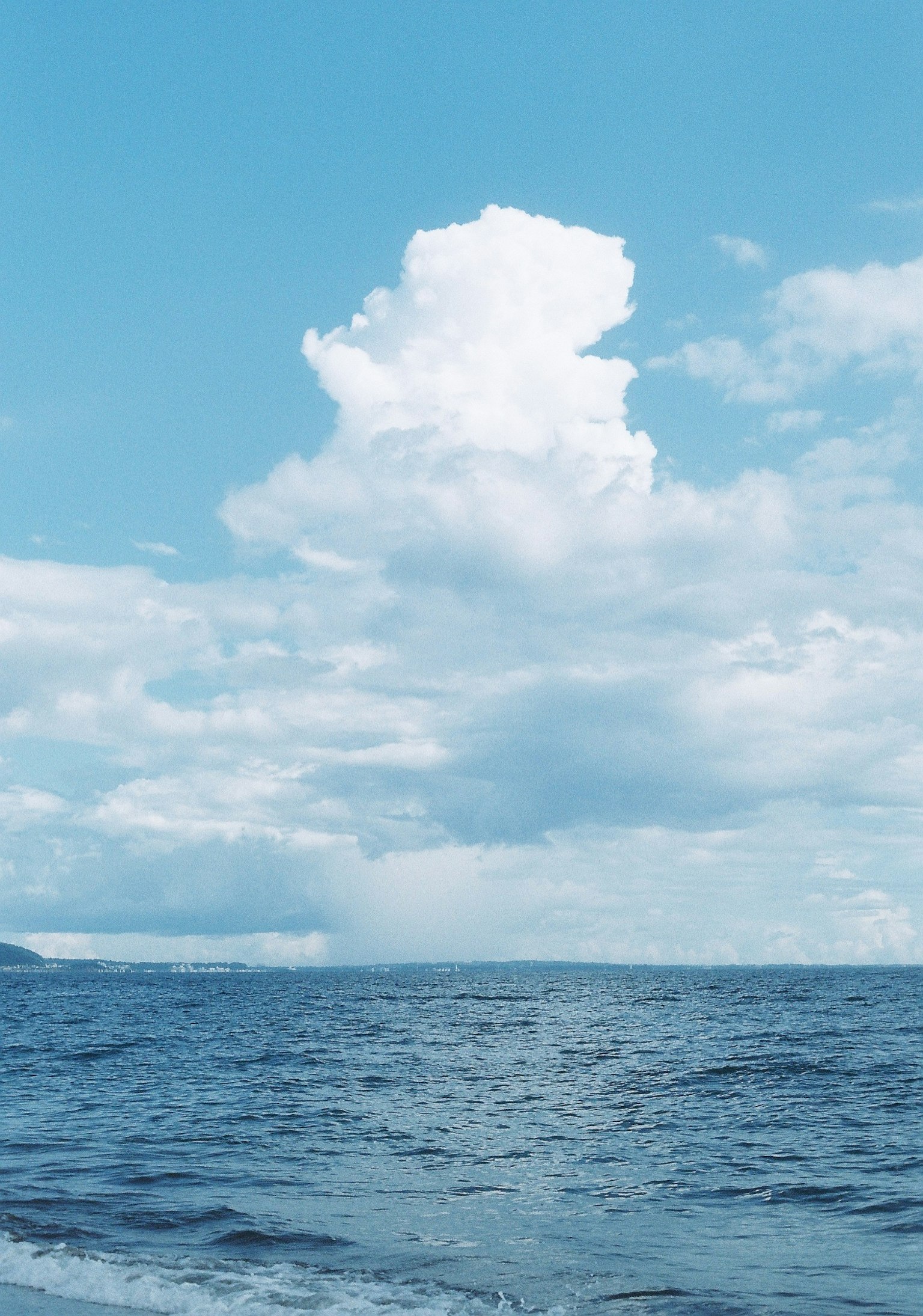 Vista serena dell'oceano con nuvole bianche e cielo azzurro