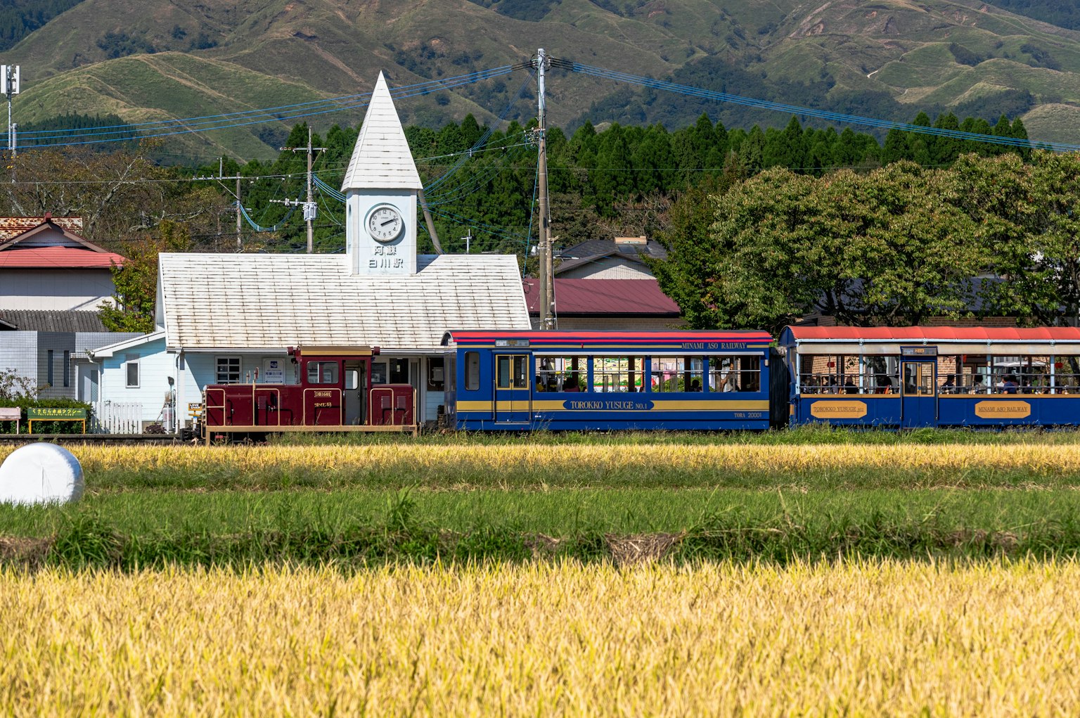 Vista panoramica di una stazione ferroviaria e di un treno in un paesaggio rurale