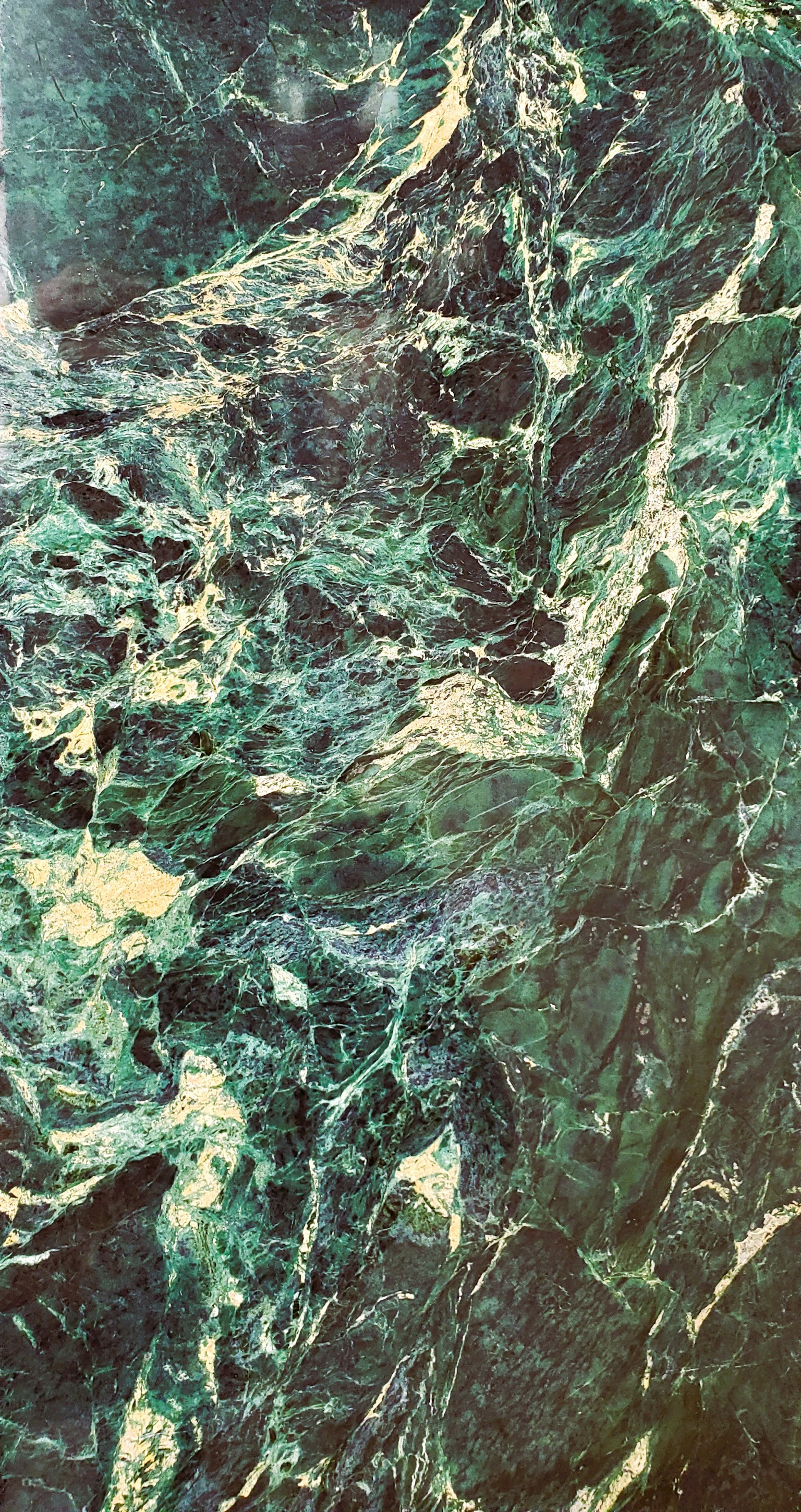 Imagen con una superficie de mármol verde texturizada y patrones intrincados