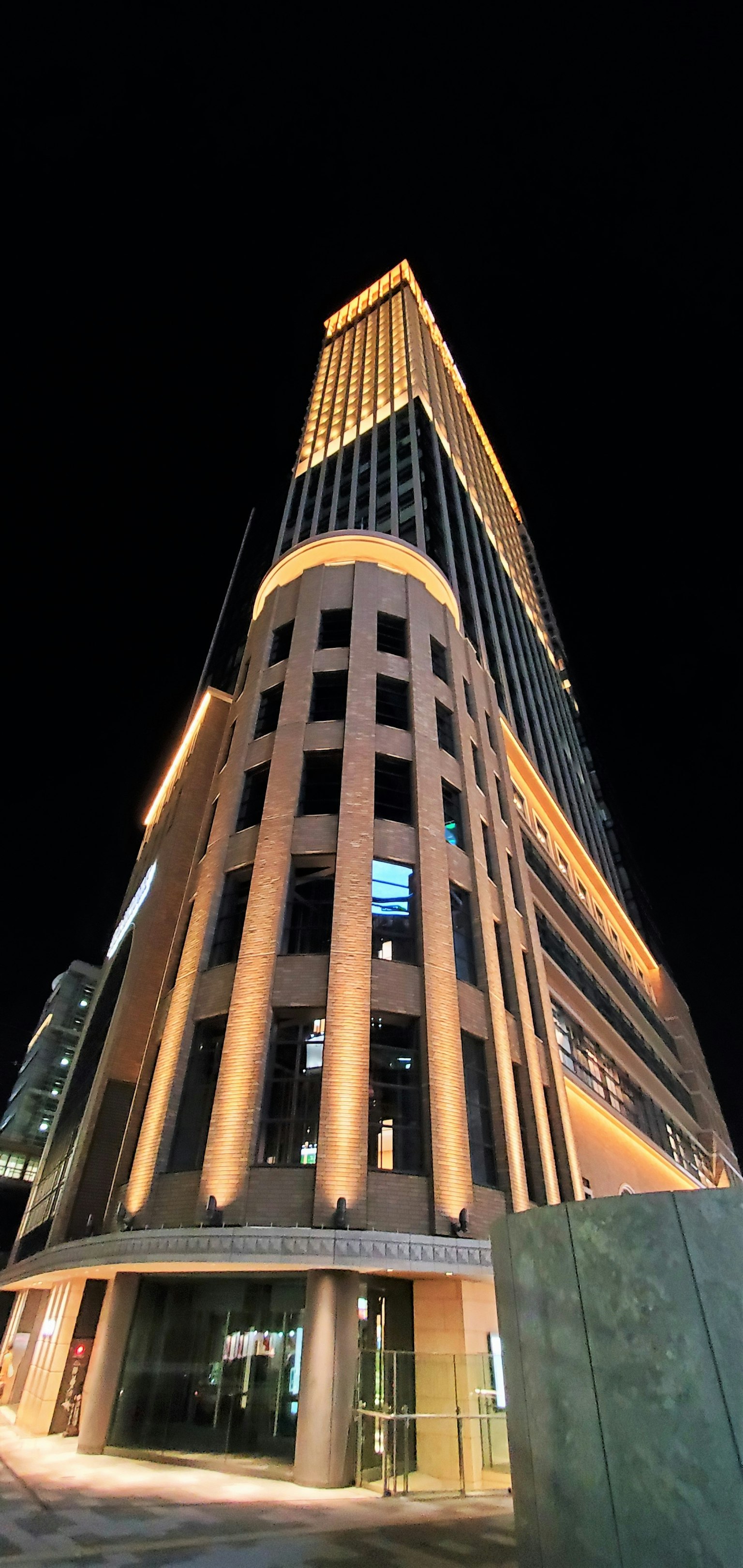 Gratte-ciel haut la nuit avec un design architectural unique mis en valeur par un éclairage lumineux
