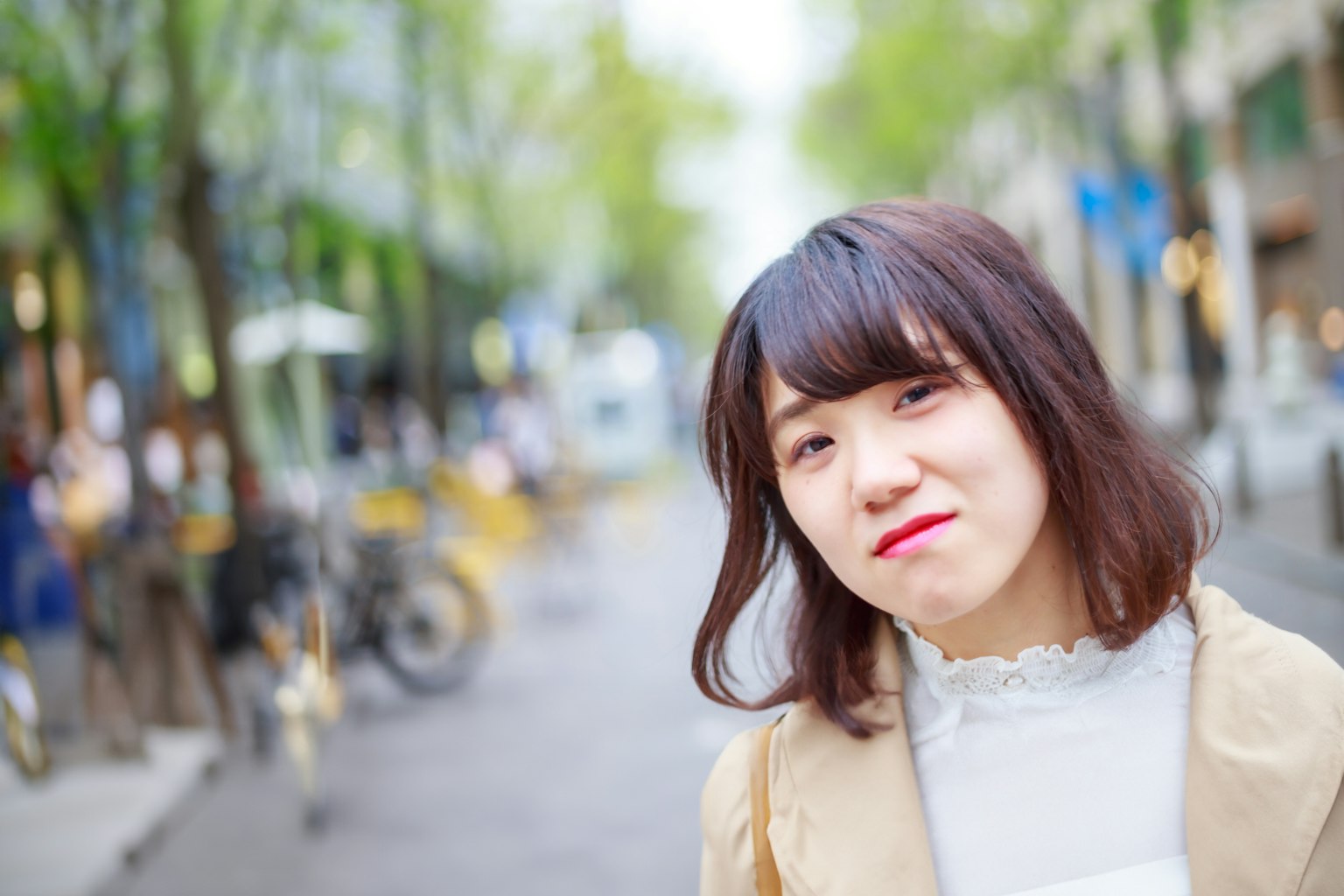 Portrait of a woman smiling in a bright urban setting