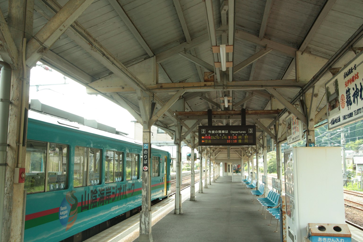 Panggung dengan kereta biru dan papan jadwal digital
