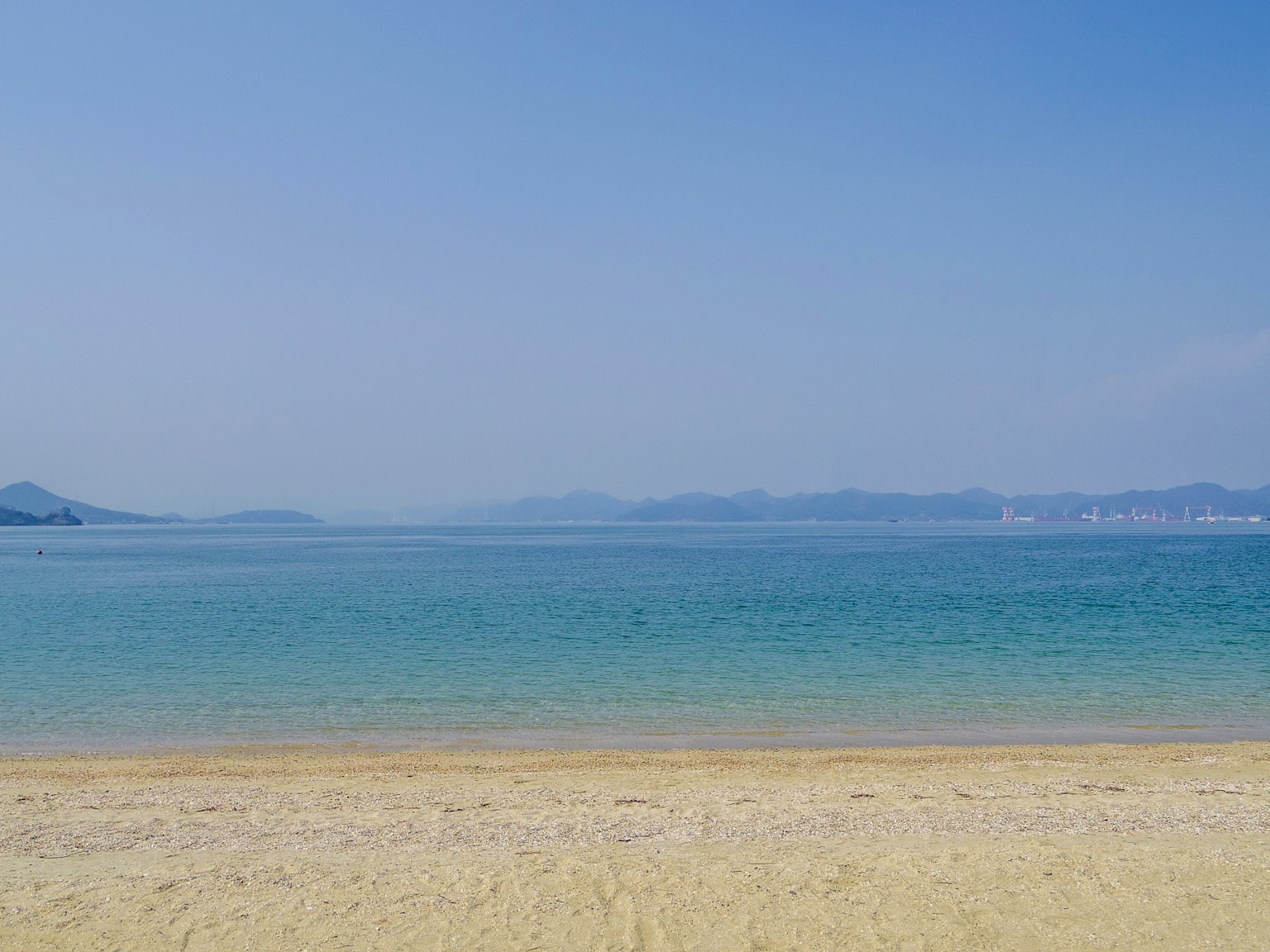 Scenic view of a blue sky and calm ocean with sandy beach