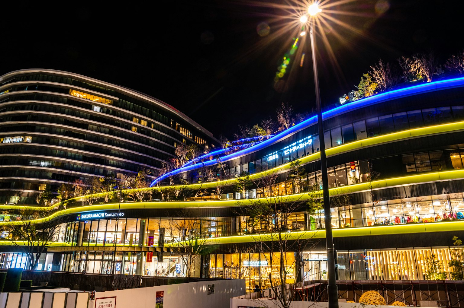 Moderne Gebäudeaußenansicht bei Nacht mit grünen Akzenten und blauer Beleuchtung