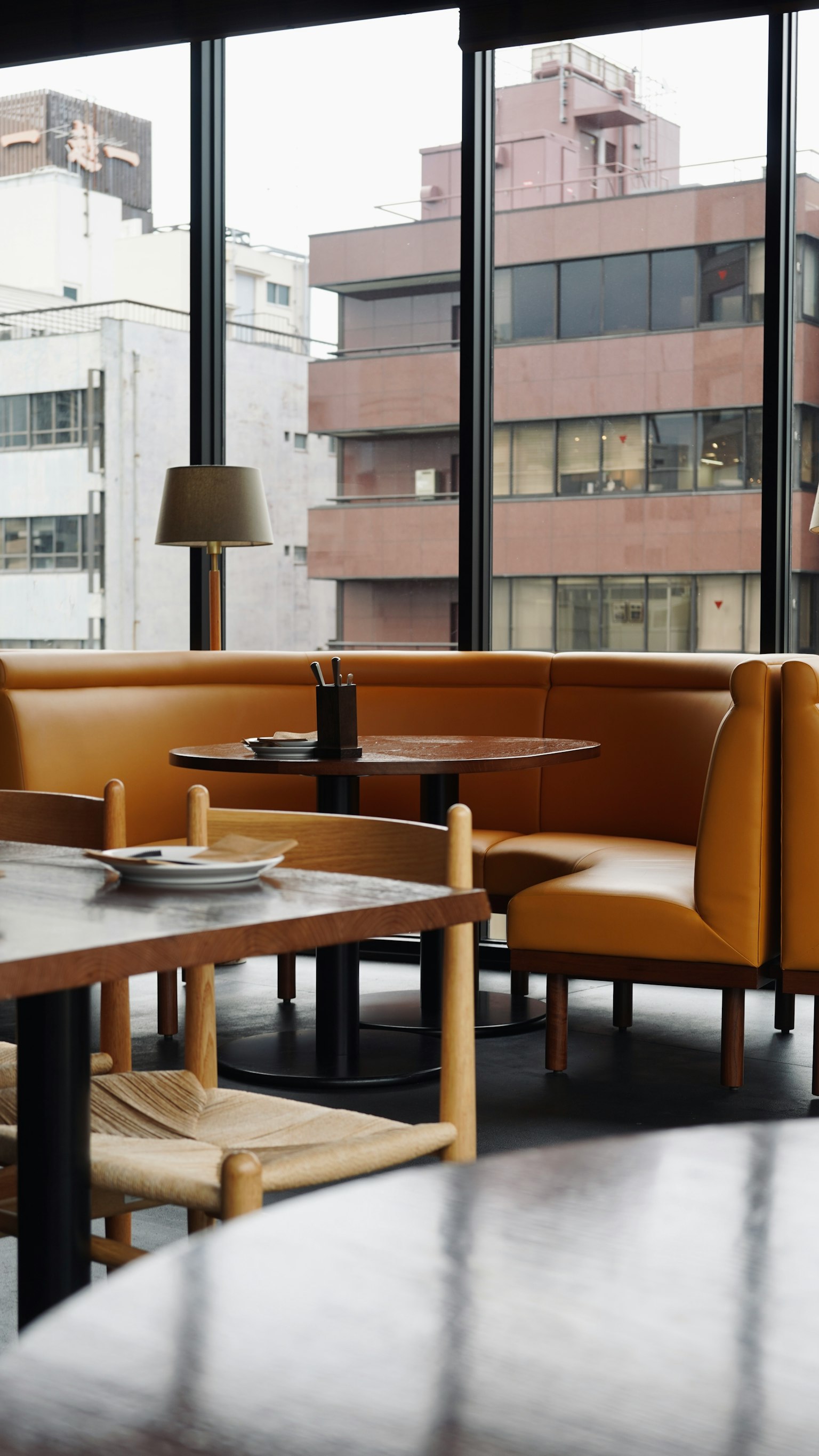 Intérieur de café moderne avec des sièges orange et des tables en bois