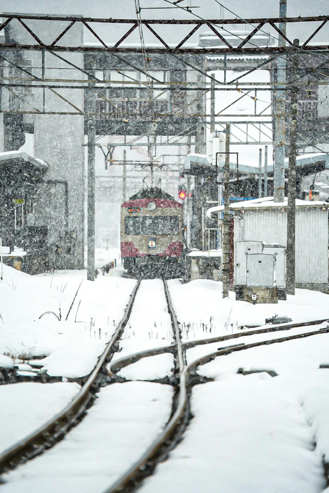 Verschneite Gleise der Omi Railway und Bahnhofsteig