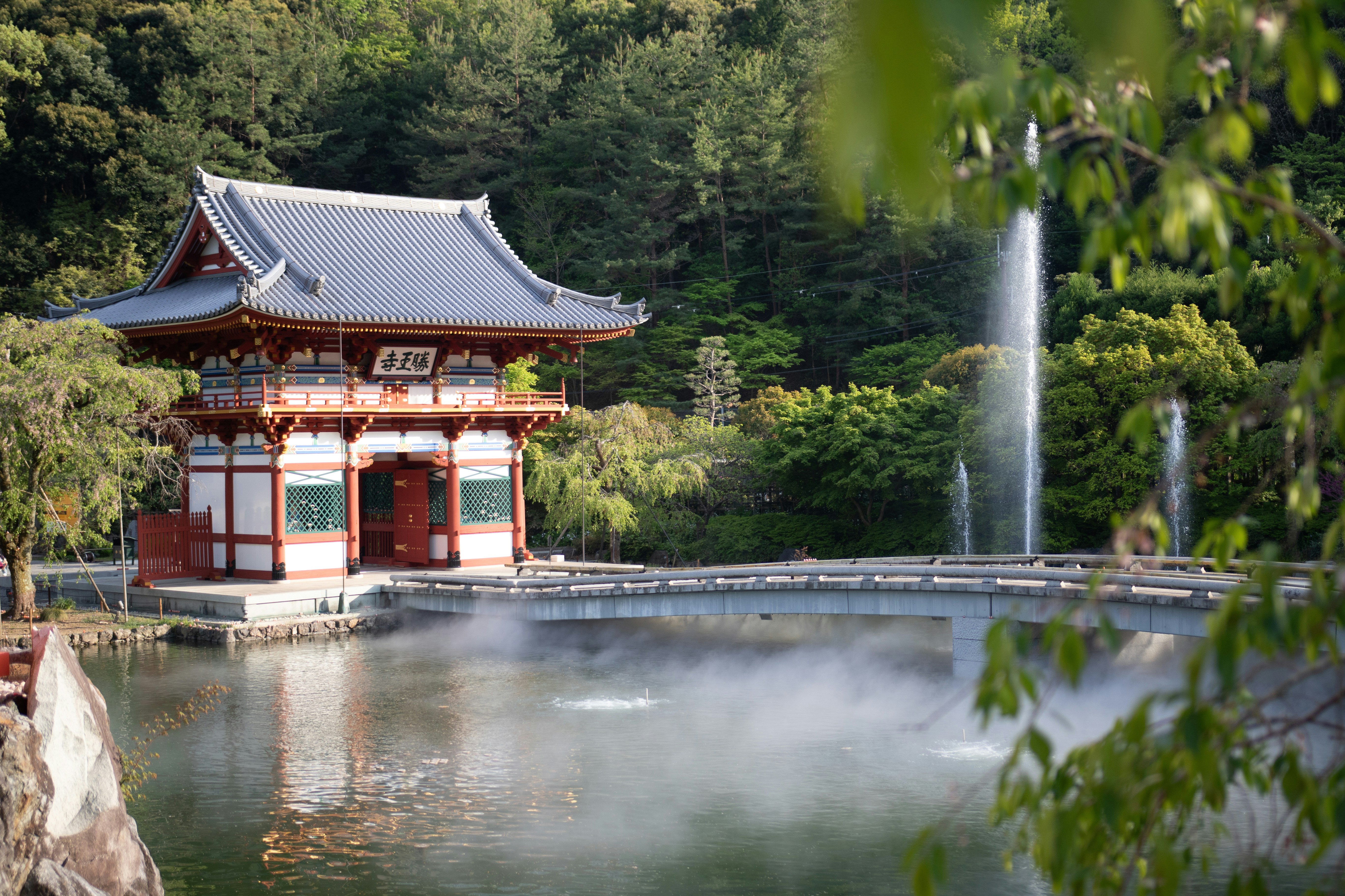 Katsuo-ji temple gate by a pond with a waterfall
