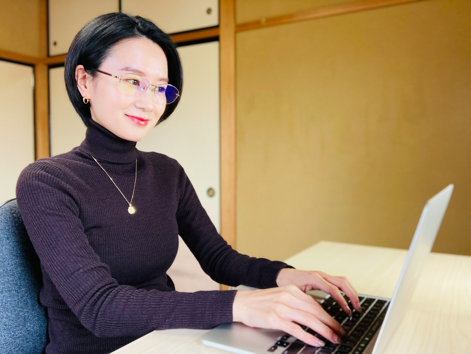 Young woman working on a laptop in an indoor setting
