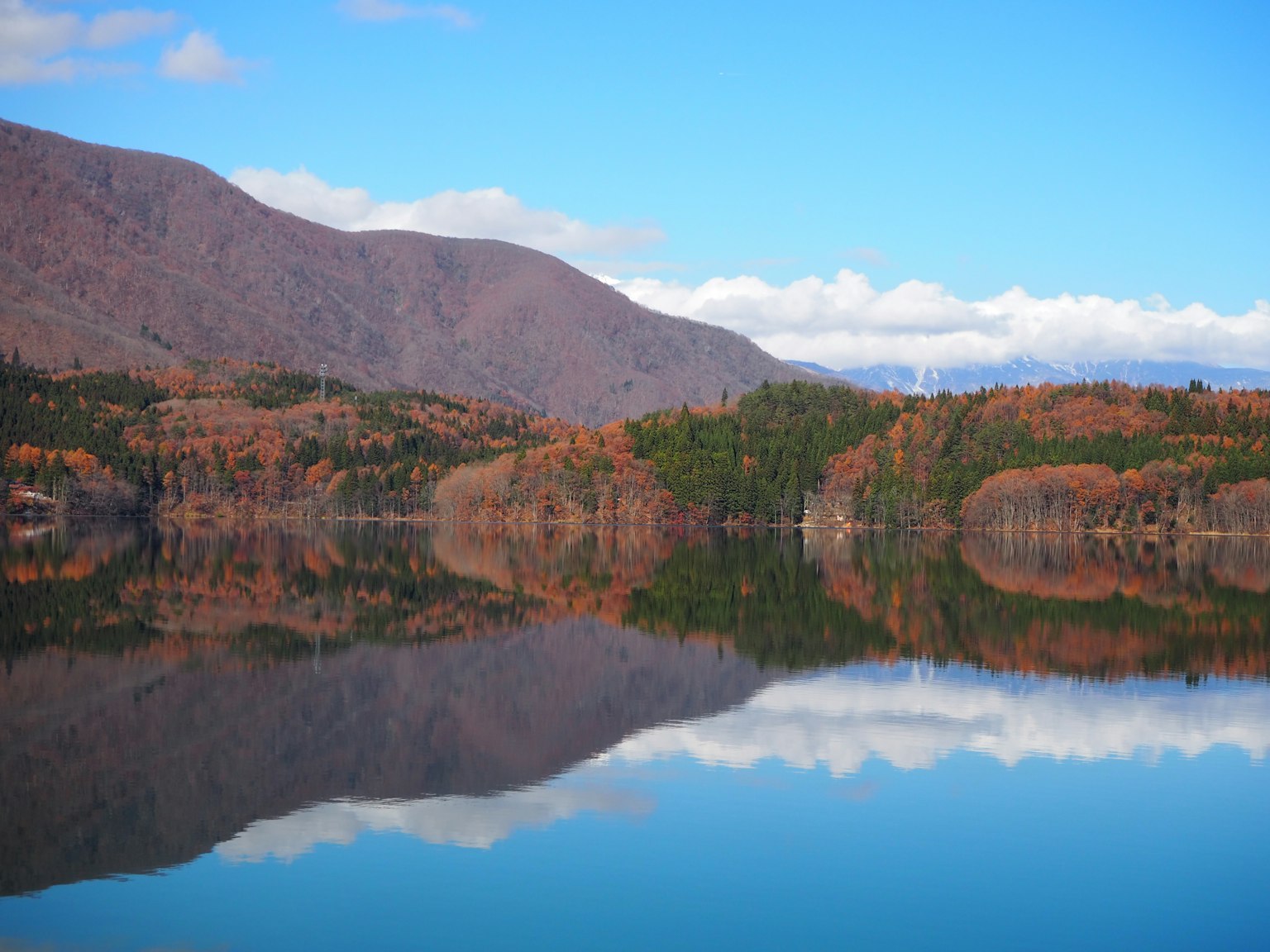 Lac calme reflétant des montagnes aux couleurs d'automne