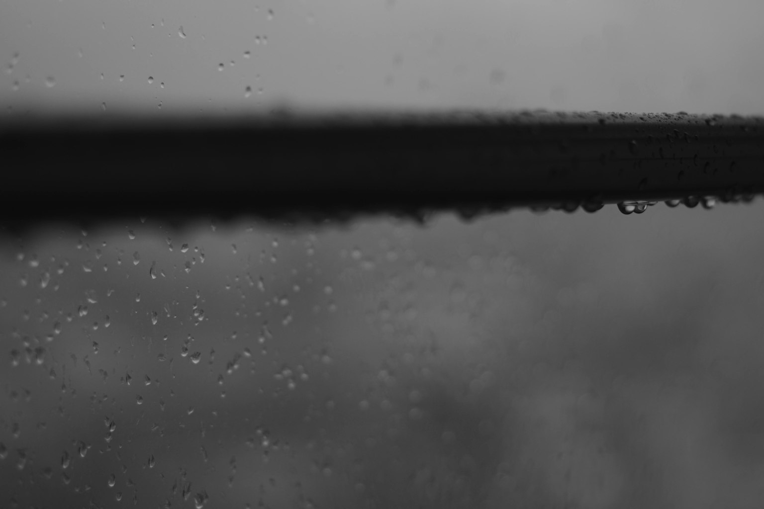 Black and white image of raindrops on a window