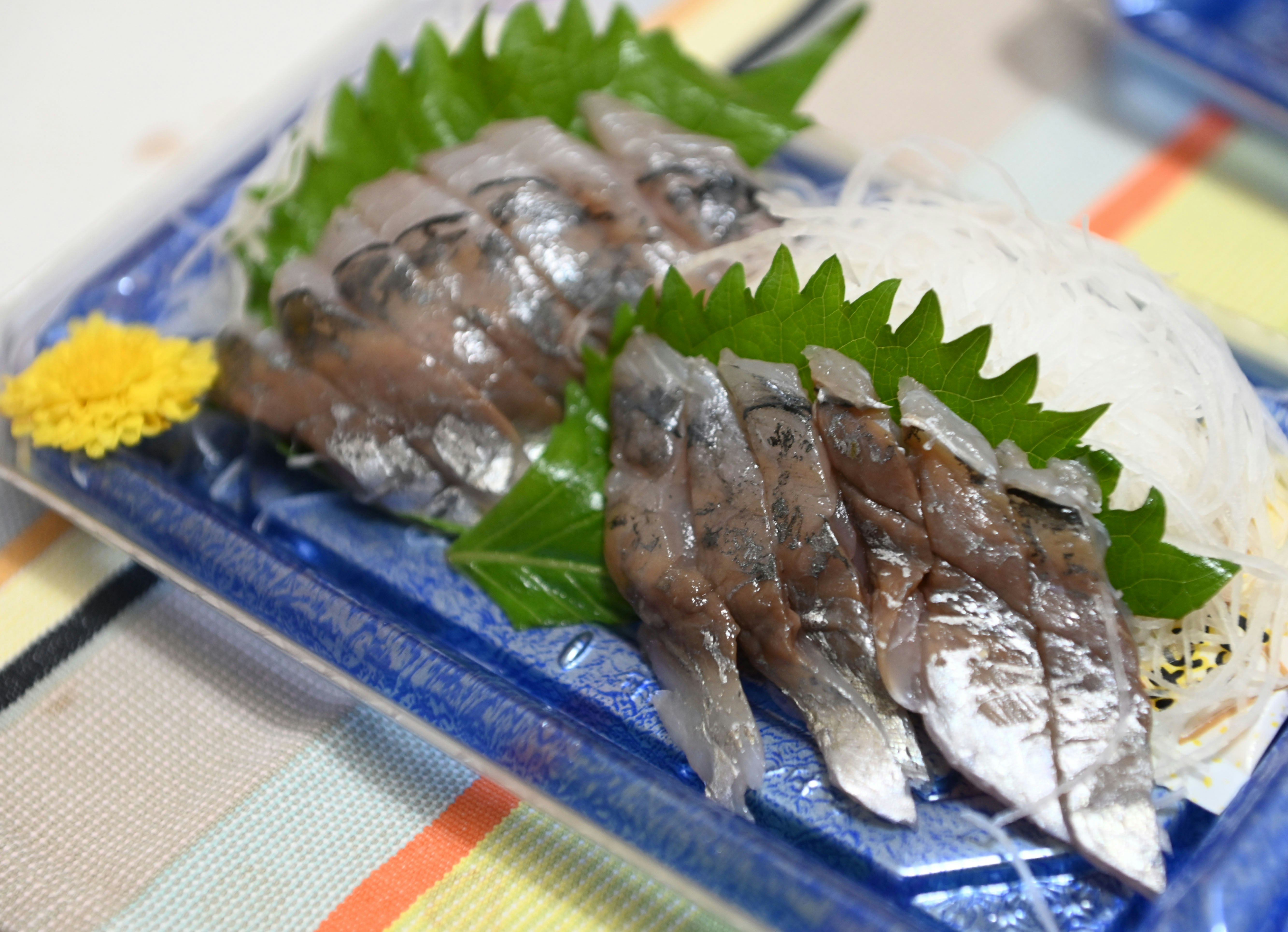 藍色盤子上的生魚片配紫蘇葉與細絲配菜