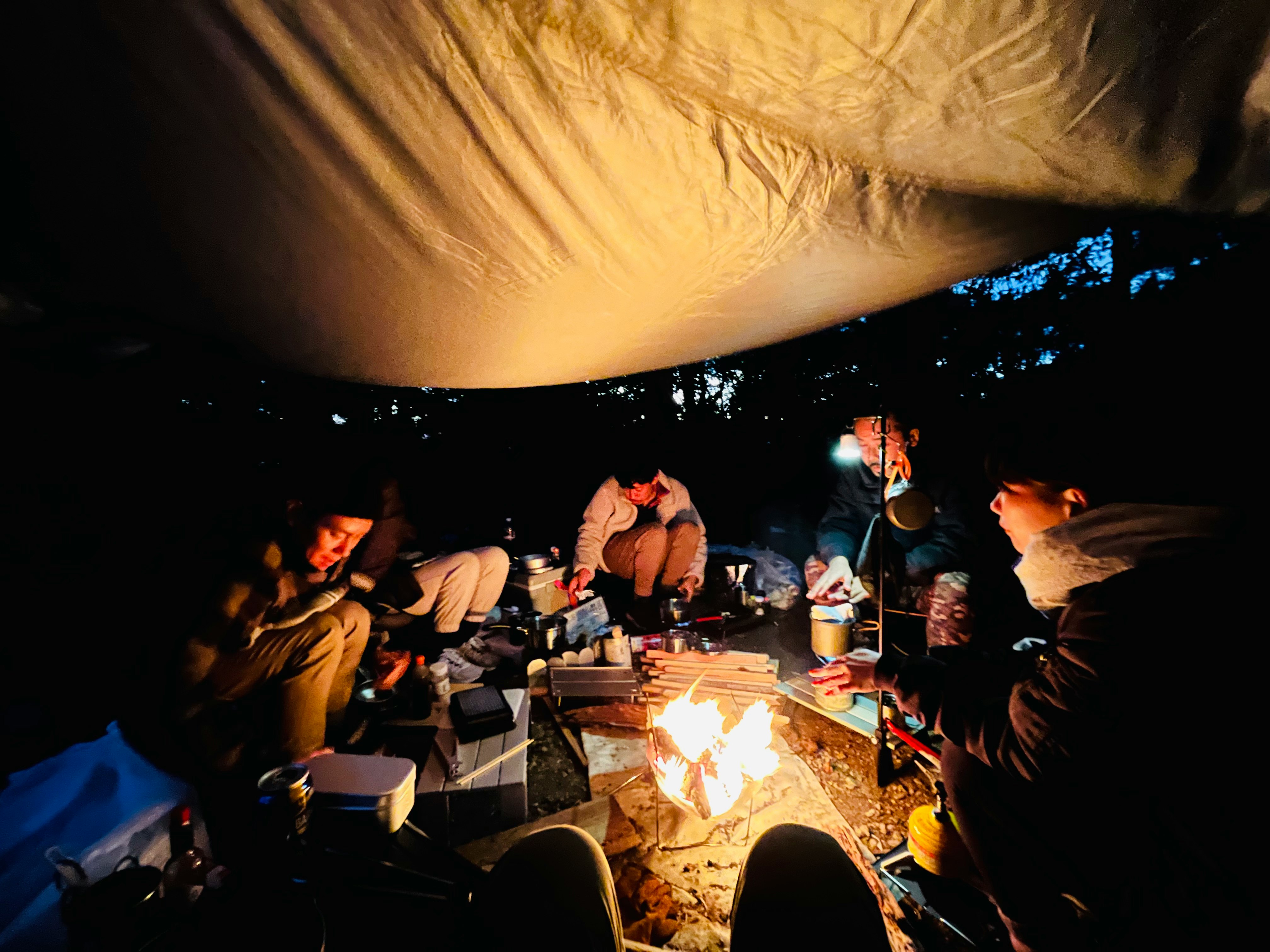 nighttime camping gathering around a campfire