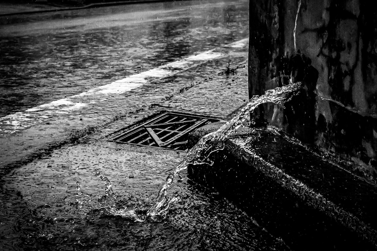 Escena de esquina de calle con agua de lluvia fluyendo hacia un desagüe