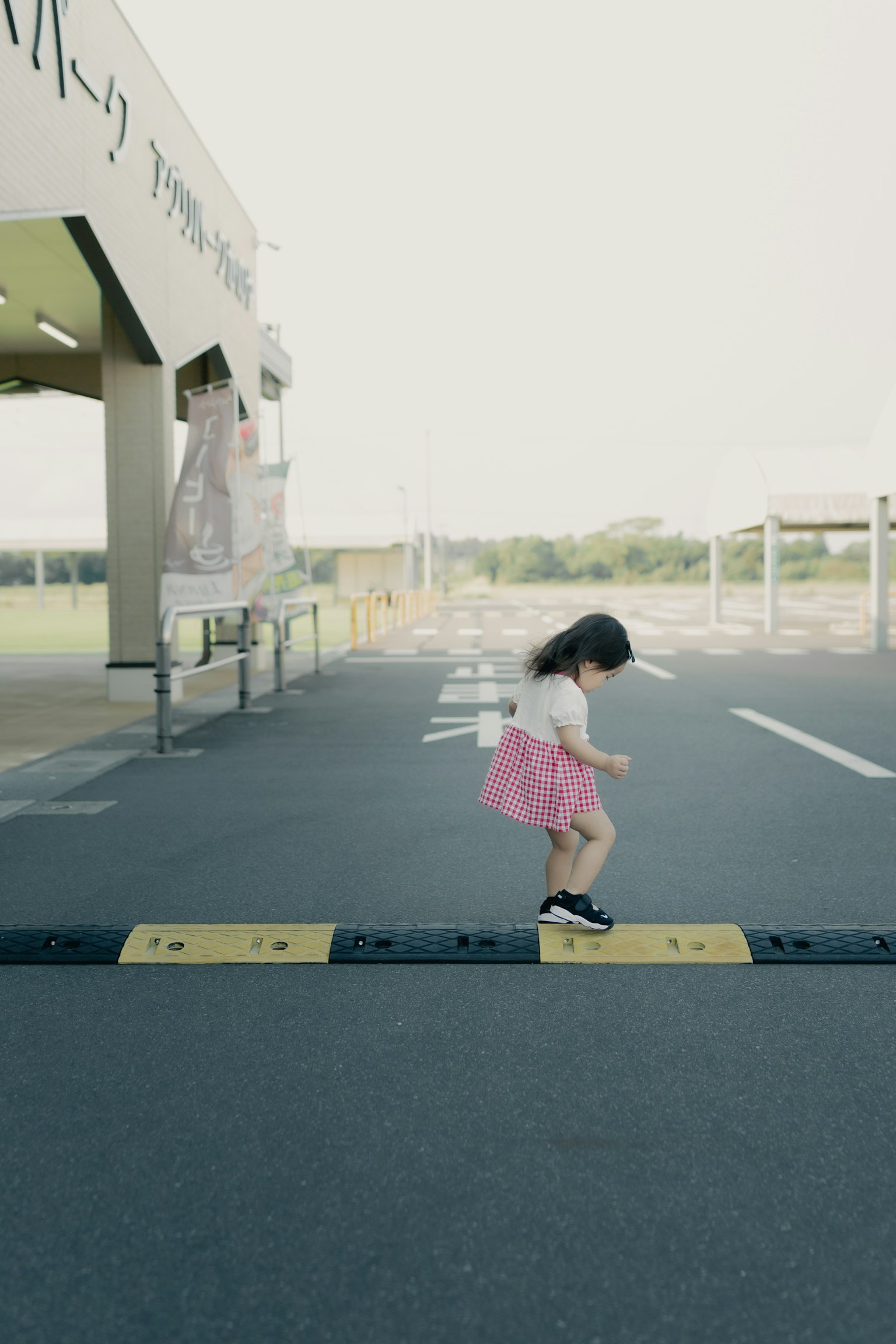 A girl wearing a pink skirt walking on a crosswalk