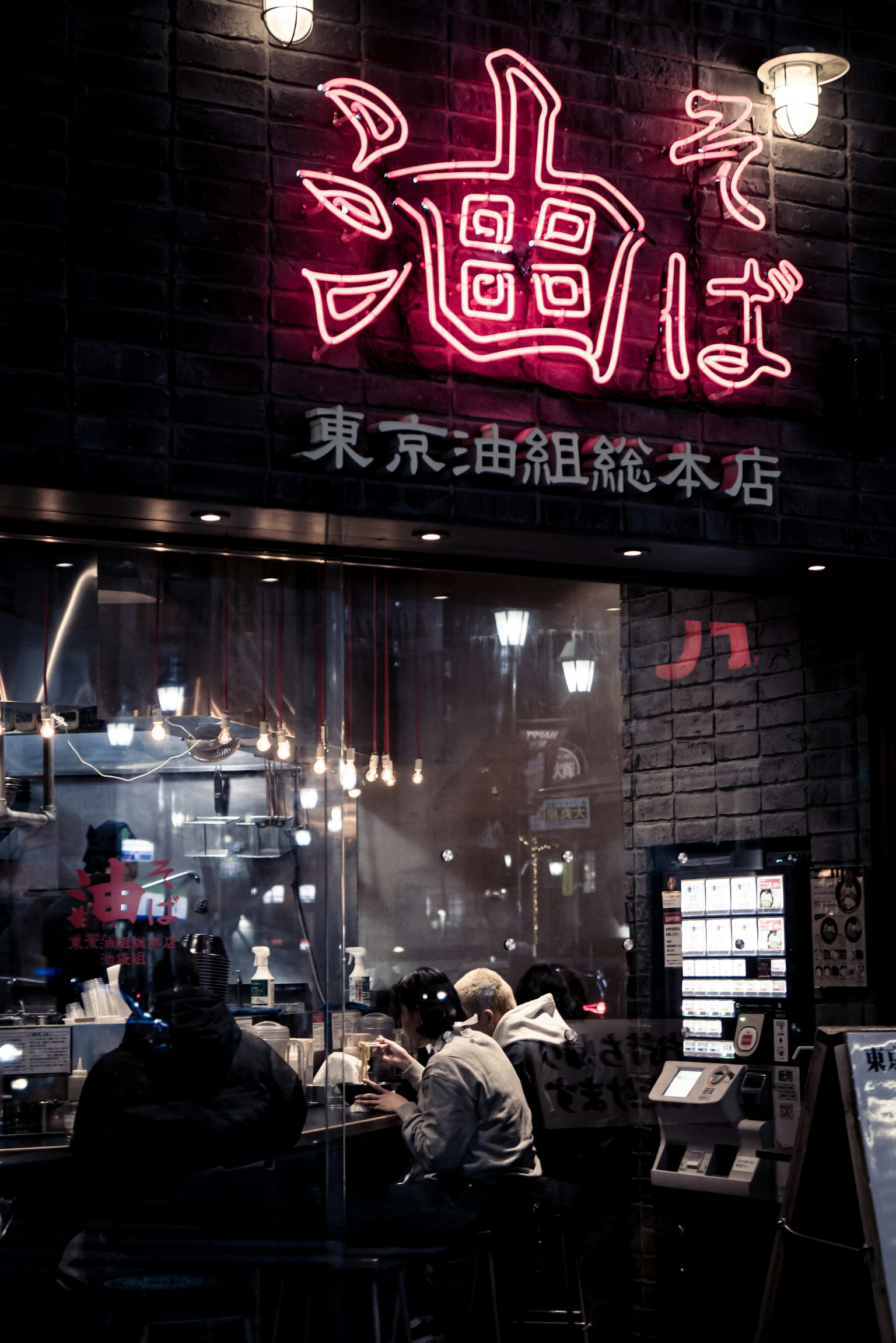 Exterior of a Tokyo ramen shop with bright neon sign