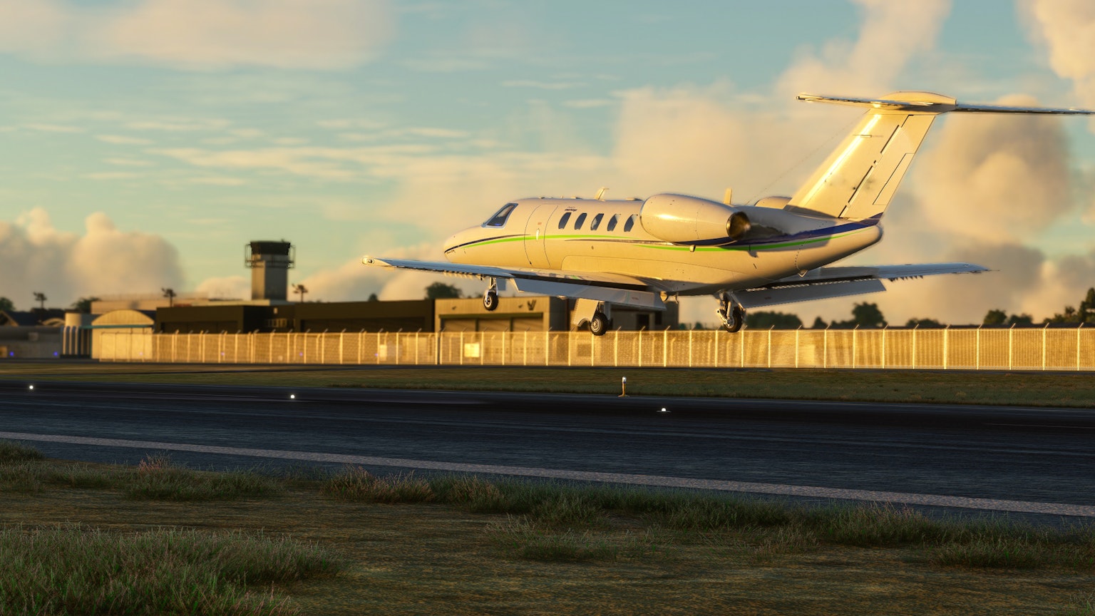 Un piccolo jet che decolla da una pista aeroportuale con una torre di controllo sullo sfondo