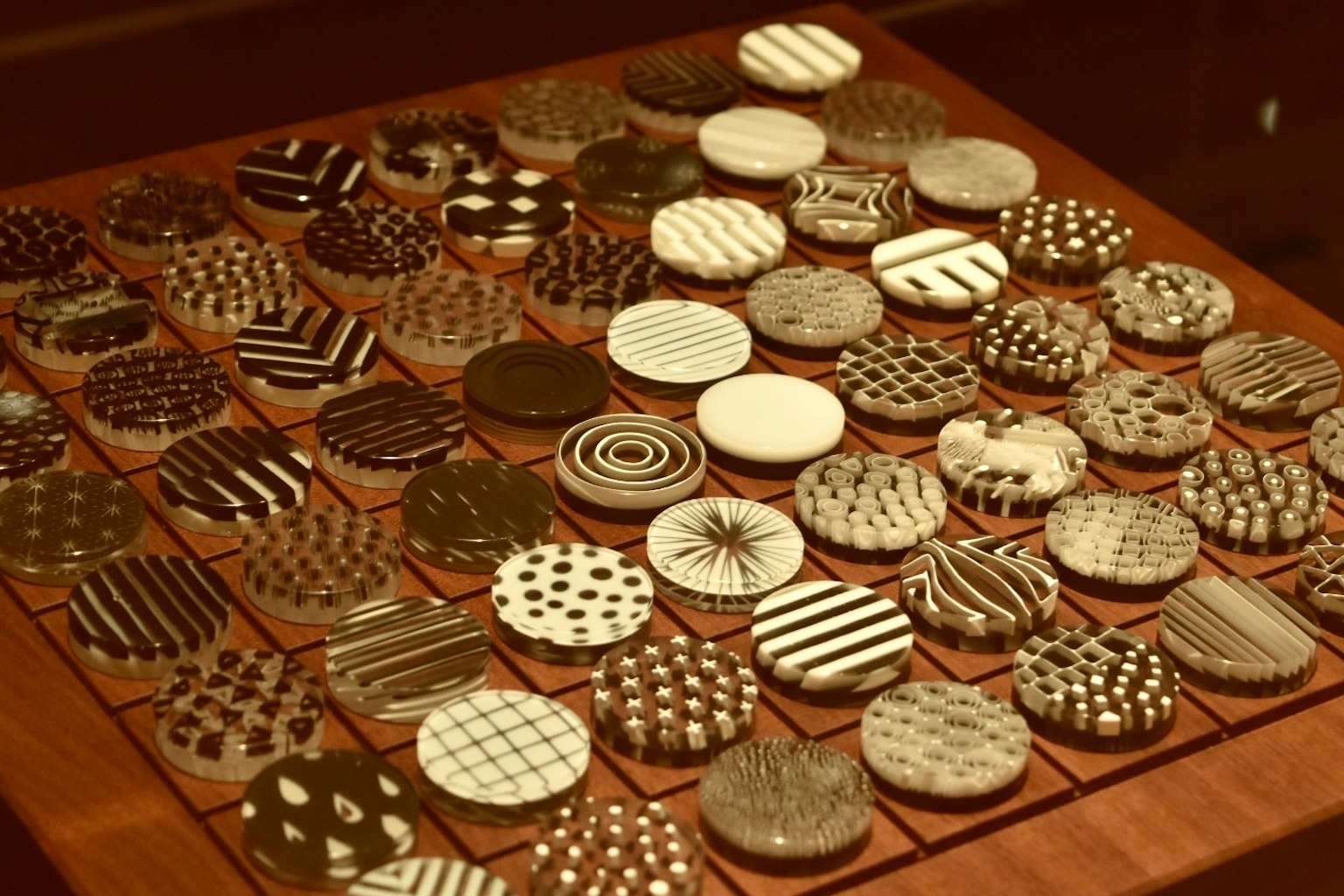 Una tabla de madera exhibiendo azulejos circulares con patrones en blanco y negro