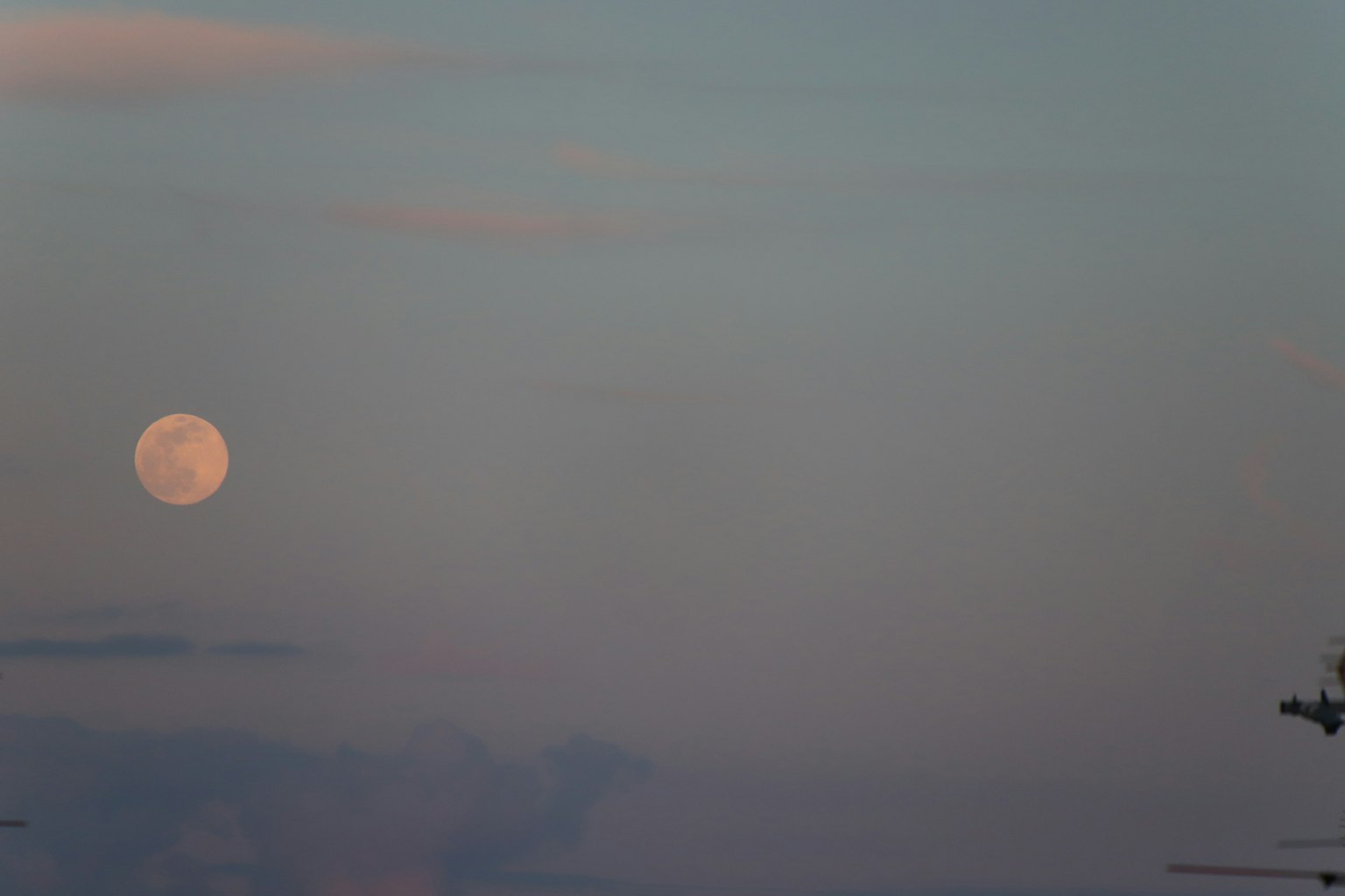 Großer Mond in einem ruhigen Himmel mit sanften Wolken
