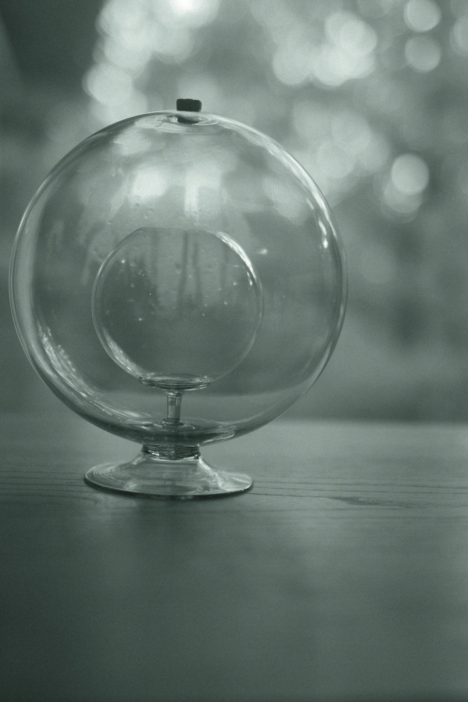 A transparent glass globe on a wooden table with a blurred background