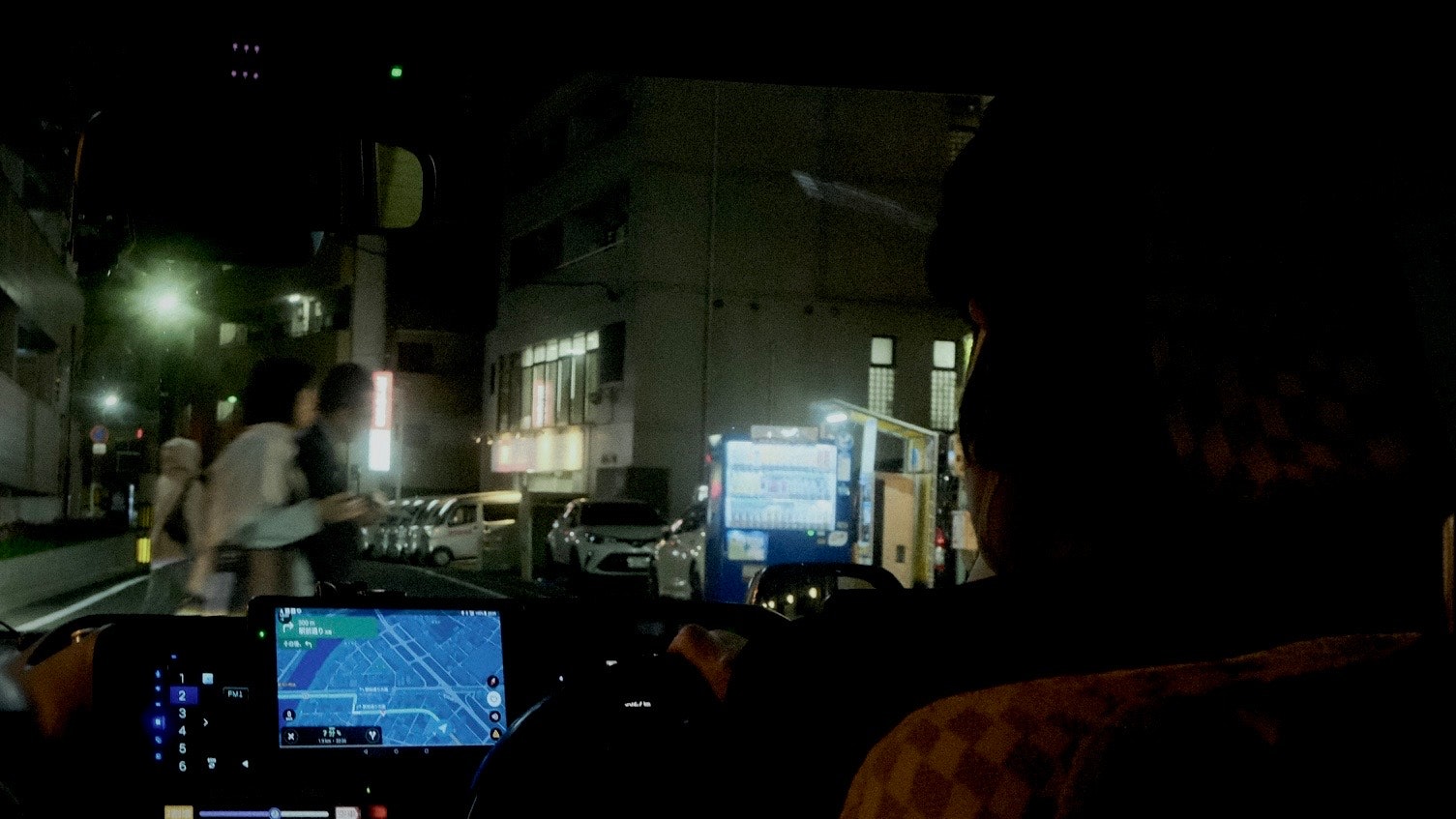 夜の路上で監視モニターを見つめる人々のある現場