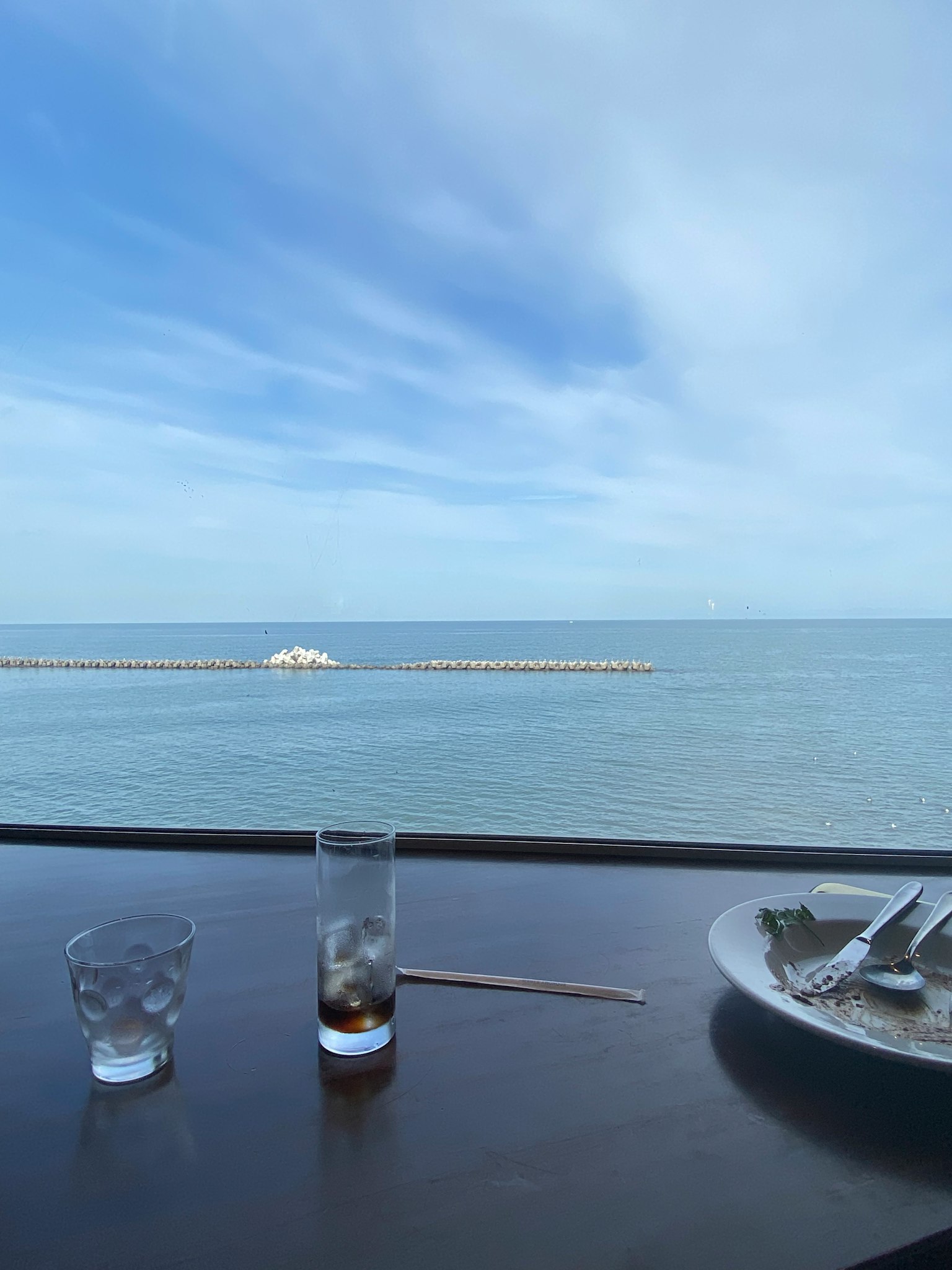 Tavolo con bevande e cibo che si affaccia sul mare