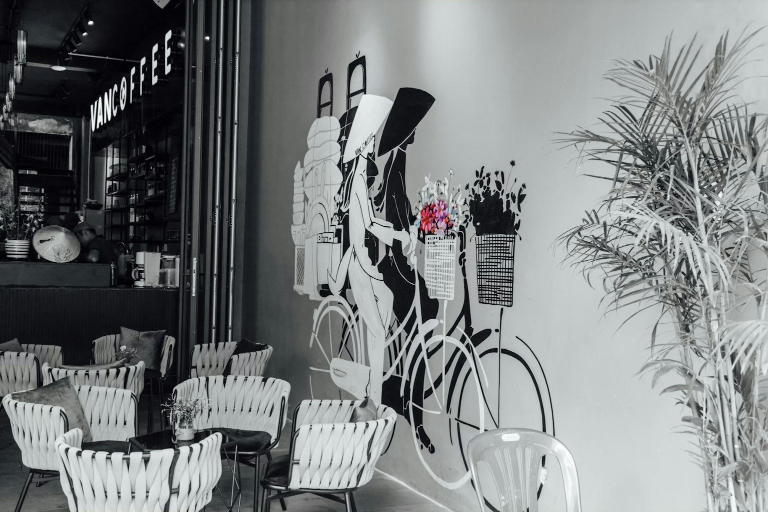 Interior kafe dengan mural sepeda putih yang dihiasi bunga