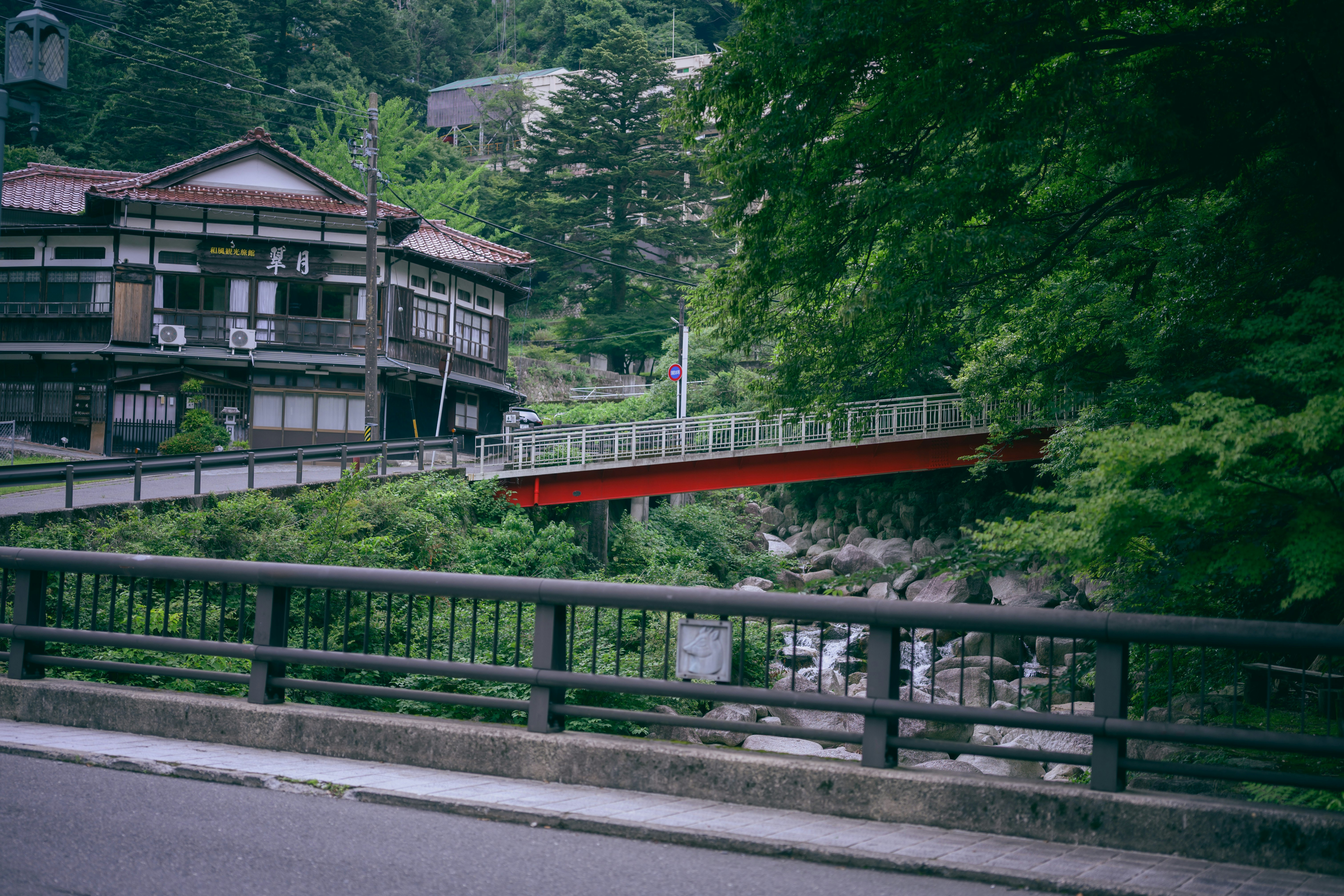 綠意山谷中的木質建築與河畔步道